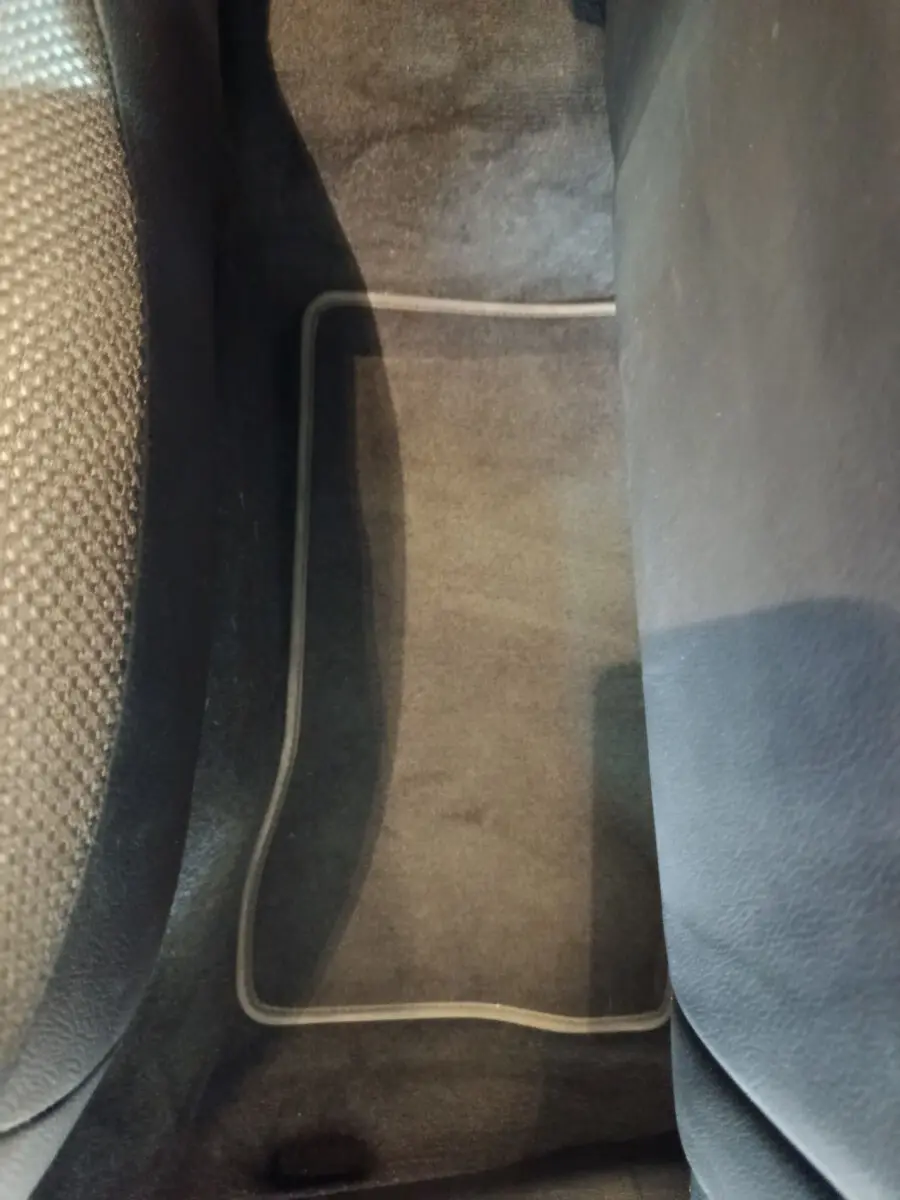 Gros plan sur le tapis de sol noir entre les sièges avant du Mercedes GLC 300 E Business Line bleu 2021 hybride rechargeable.