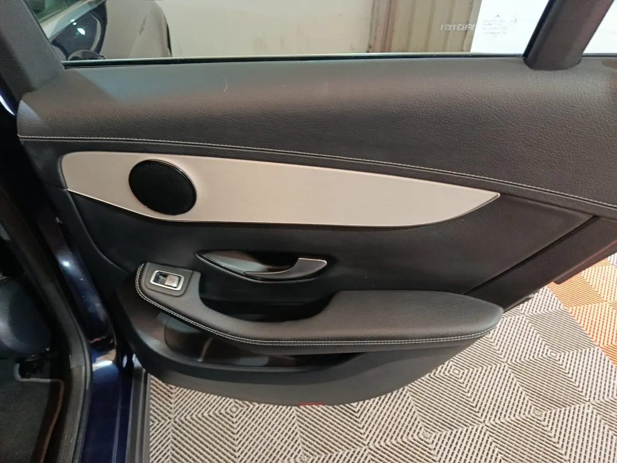 Gros plan sur la porte arrière gauche bleu foncé du Mercedes GLC 300 e Business Line avec garniture cuir noire et insert aluminium.