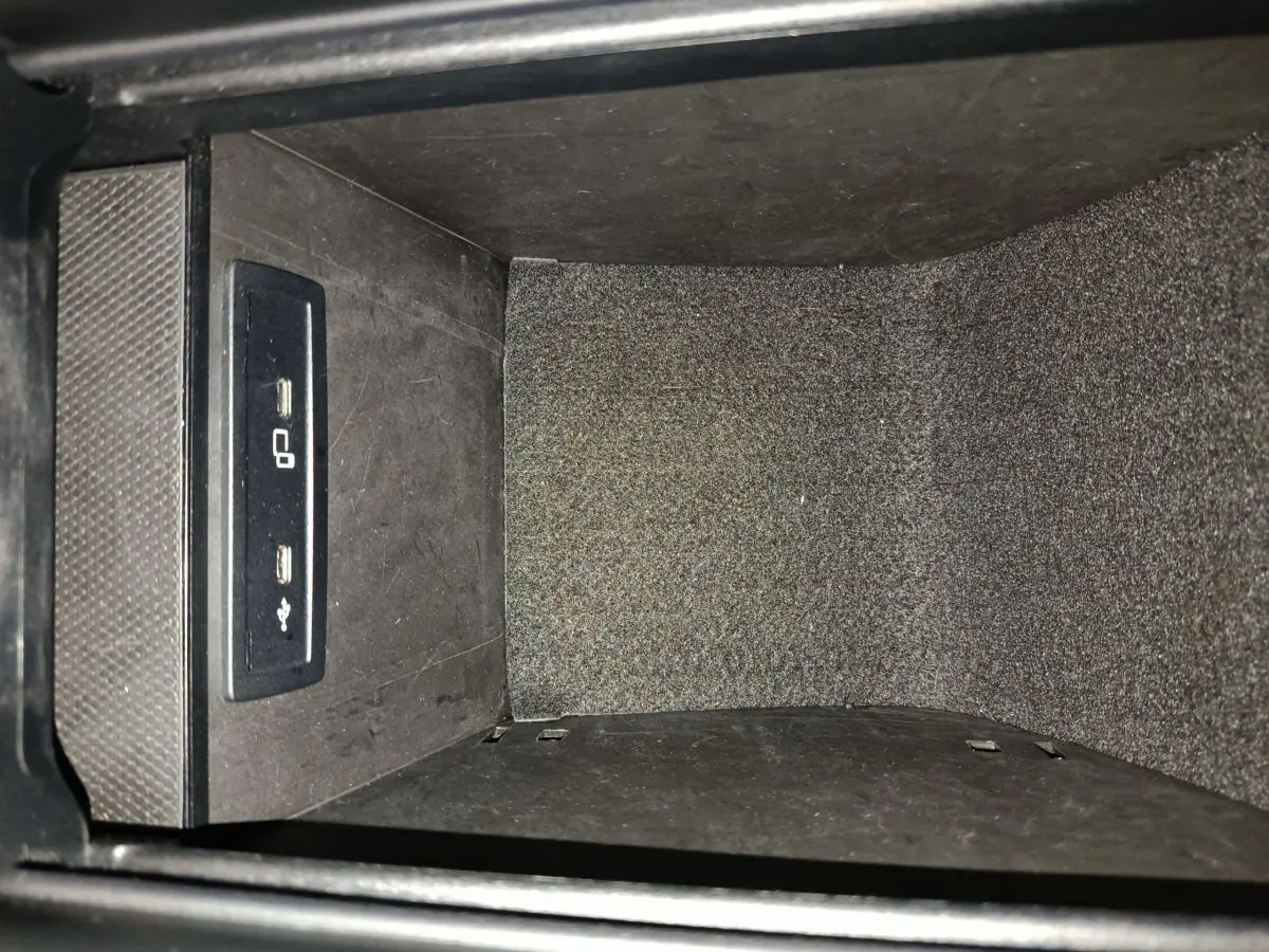 Vue rapprochée de la prise USB et port de chargement dans l'accoudoir central du Mercedes GLC 300 E bleu 2021 hybride rechargeable.