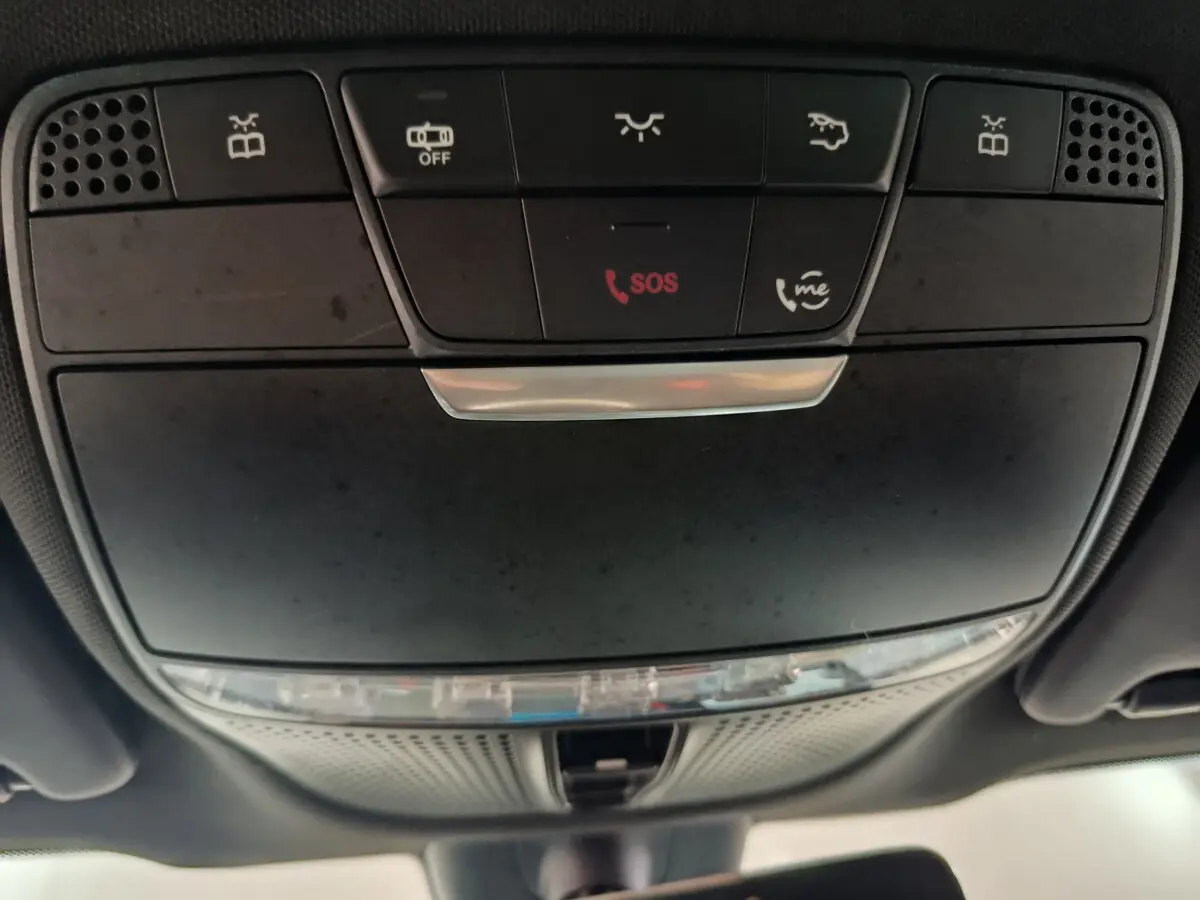 Vue en contre-plongée du panneau de commandes plafond noir du Mercedes GLC 300 E Business Line 2021 avec bouton SOS rouge.