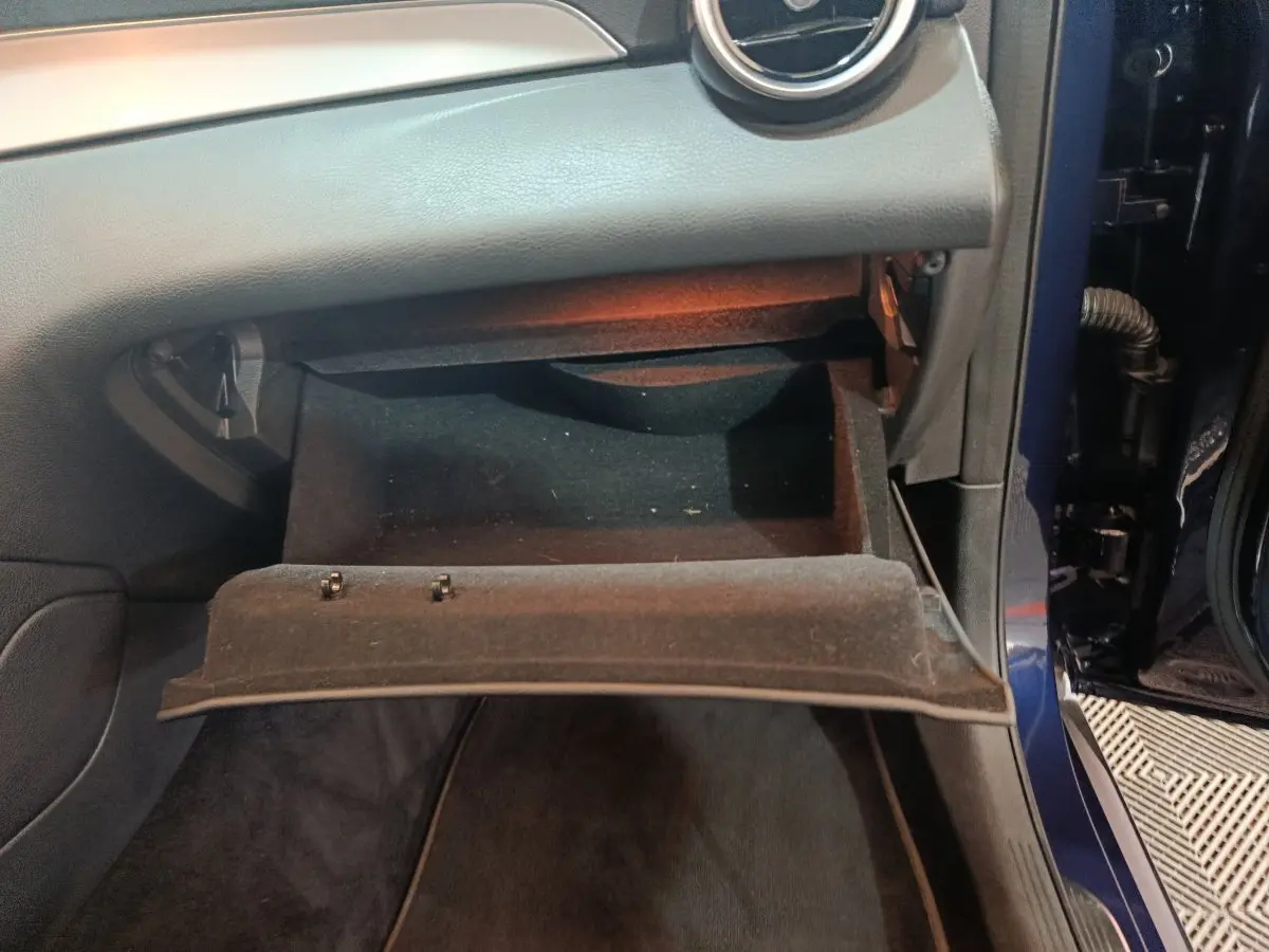 Gant de boîte à gants ouvert côté passager dans l’habitacle bleu d’un Mercedes GLC 300 E Business Line 2021 hybride rechargeable.