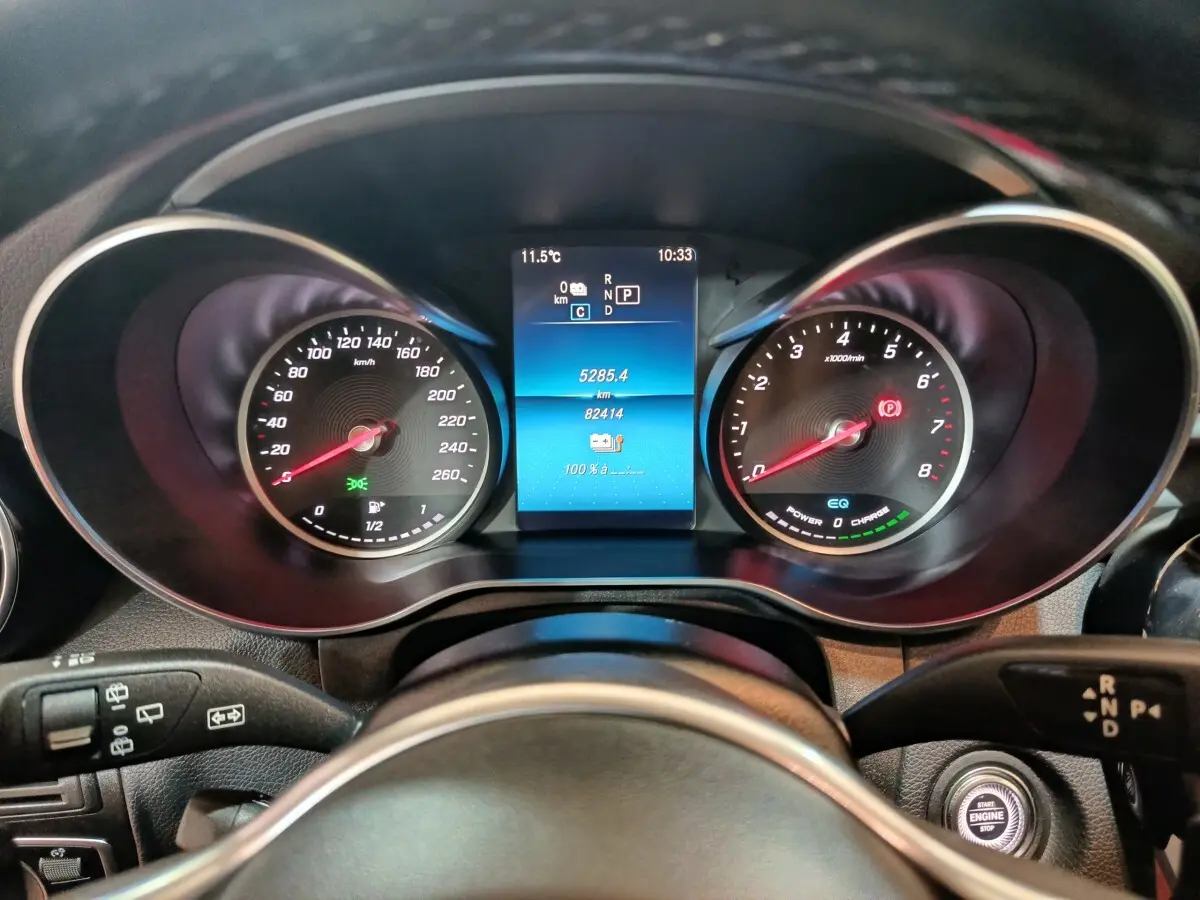 Vue rapprochée du tableau de bord numérique du Mercedes GLC 300 E hybride rechargeable avec affichages et commandes au volant.