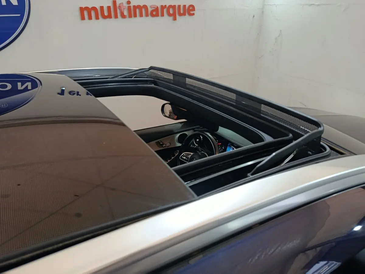 Vue rapprochée du toit ouvrant panoramique ouvert d’un Mercedes GLC bleu, dévoilant l’intérieur côté conducteur.