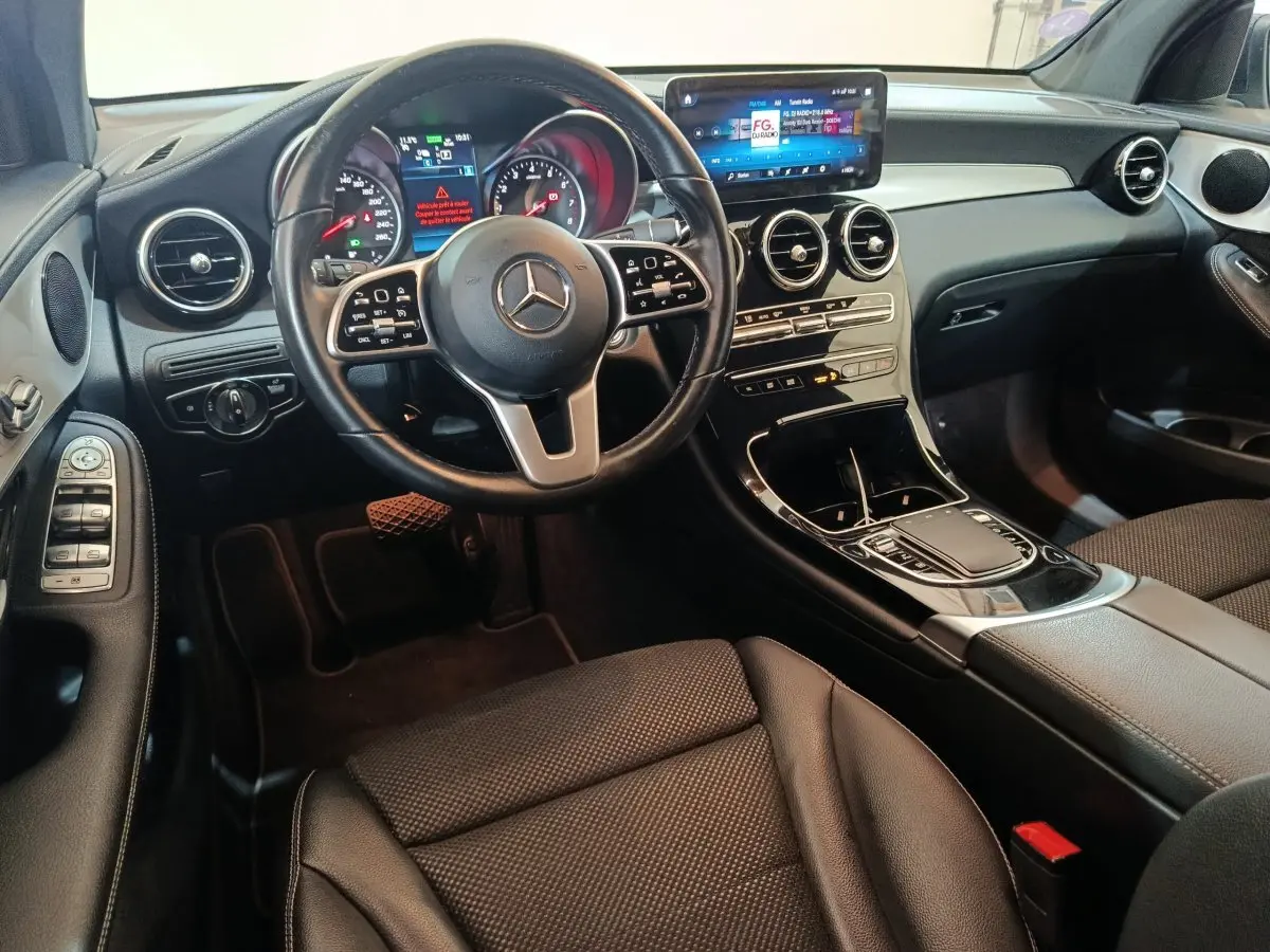 Intérieur noir du Mercedes GLC 300 E Business Line 2021 vu côté conducteur, avec tableau de bord digital et écran tactile central.