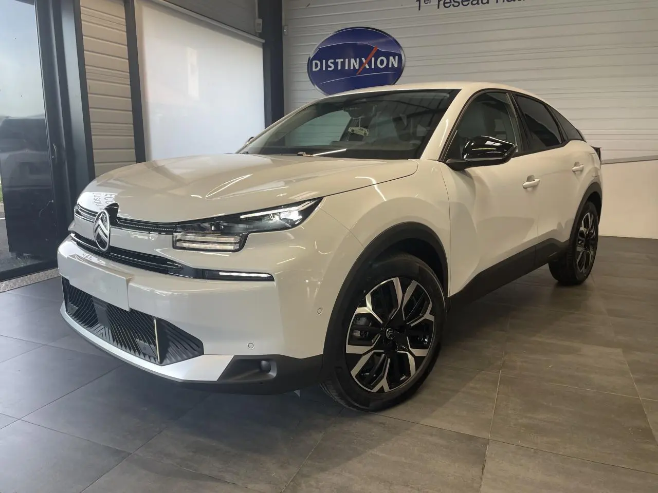 Citroën C4 hybride blanc métallisé vue 3/4 avant avec jantes alliage 18'' et rétroviseurs noirs brillants.