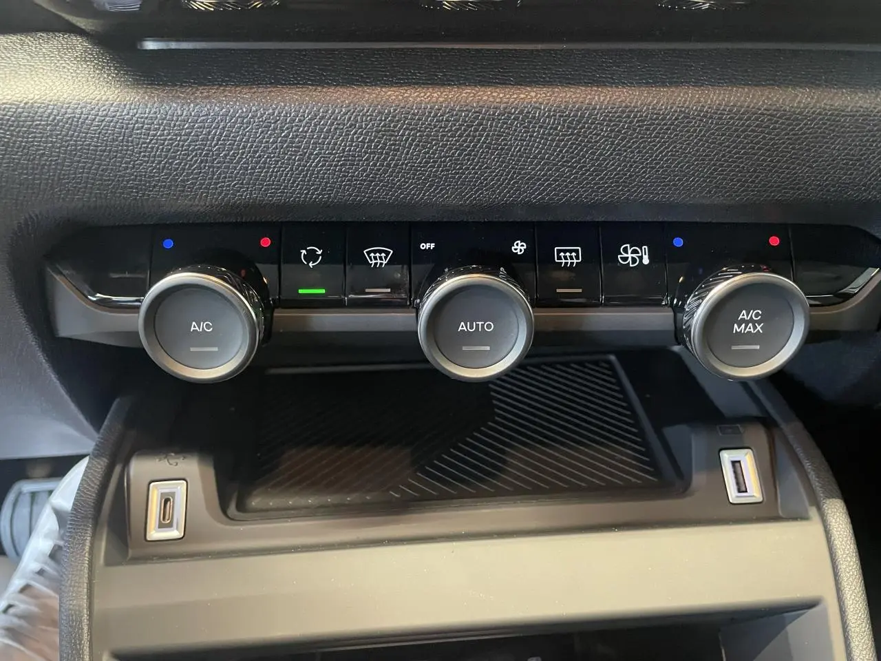 Vue rapprochée de la console centrale avec commandes de climatisation automatique bi-zone et prises USB dans une Citroën C4 blanche.