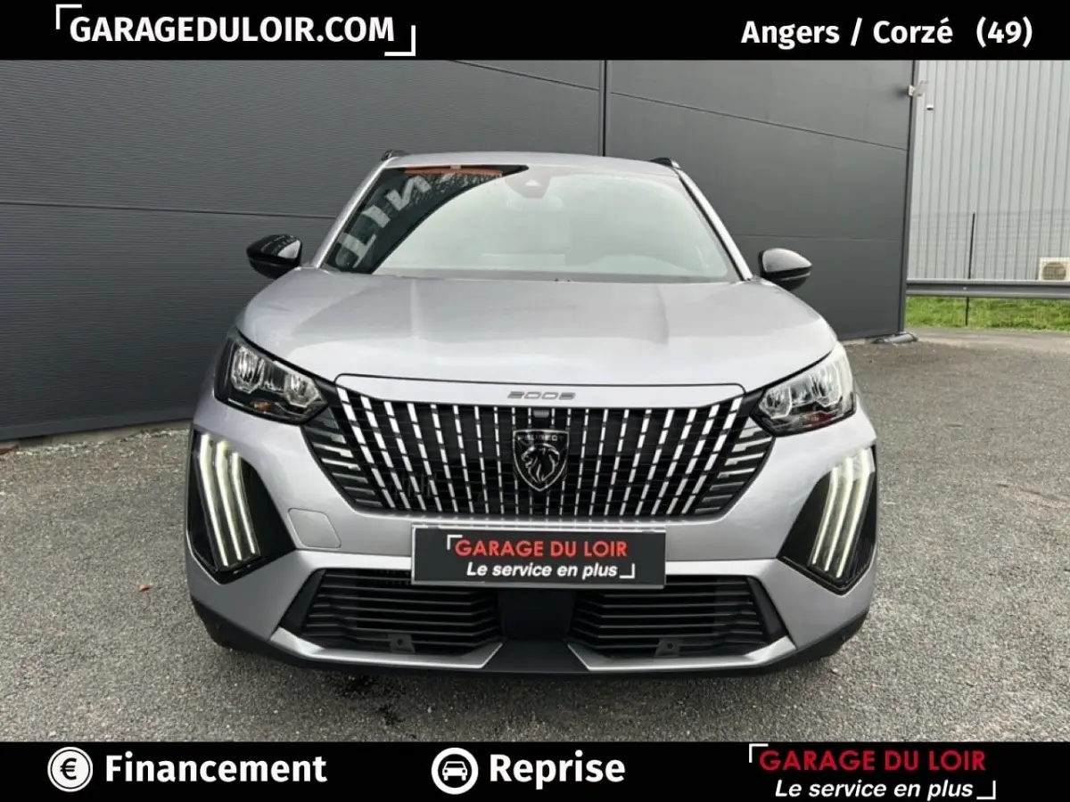 Vue avant d’un Peugeot 2008 Hybrid gris clair 2025 avec calandre verticale distinctive et feux LED verticaux allumés.