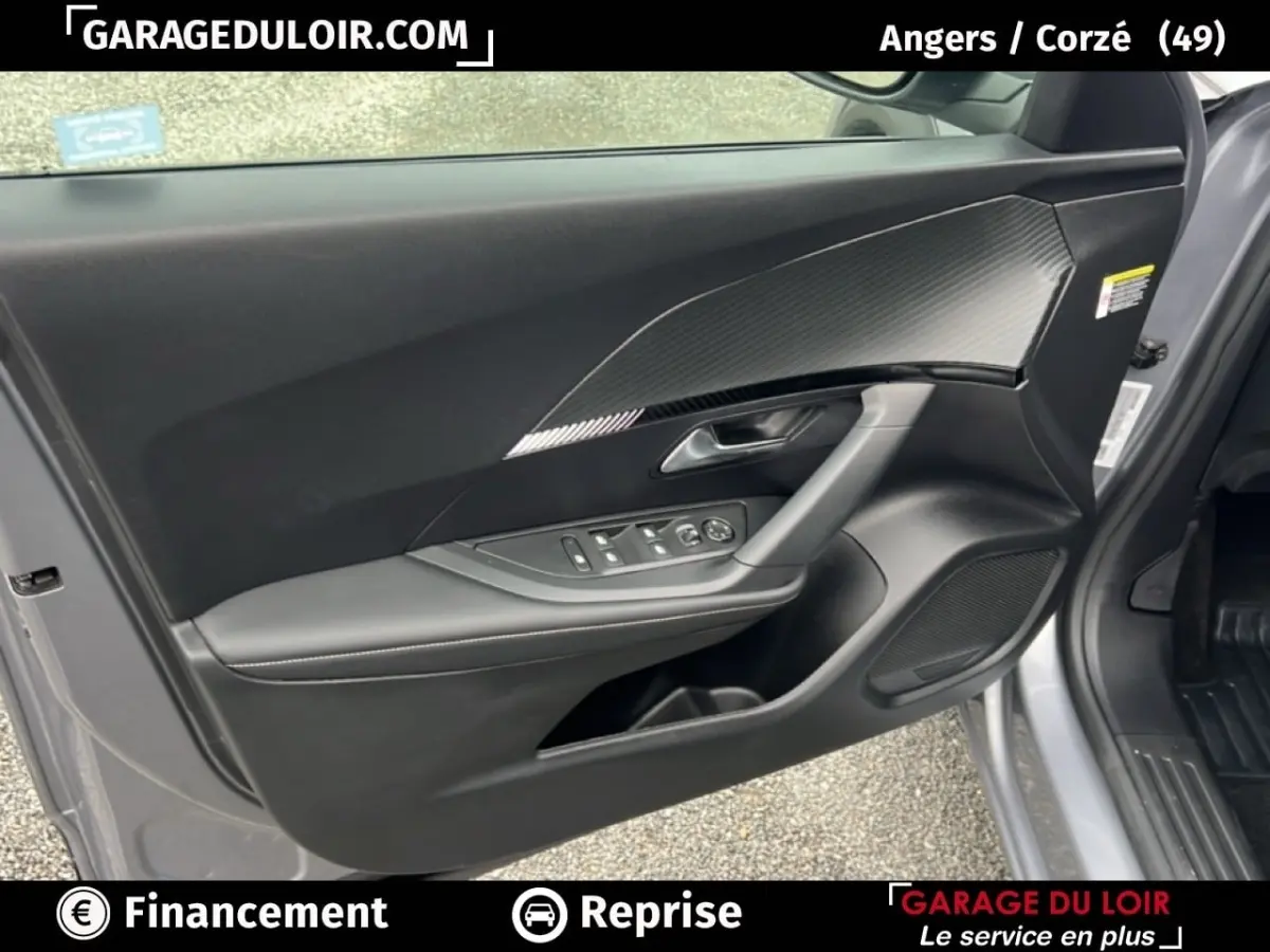 Vue intérieure côté gauche de la porte avant d’une Peugeot 2008 Hybrid 136 e-DCS6 Allure gris clair avec habillage carbone.