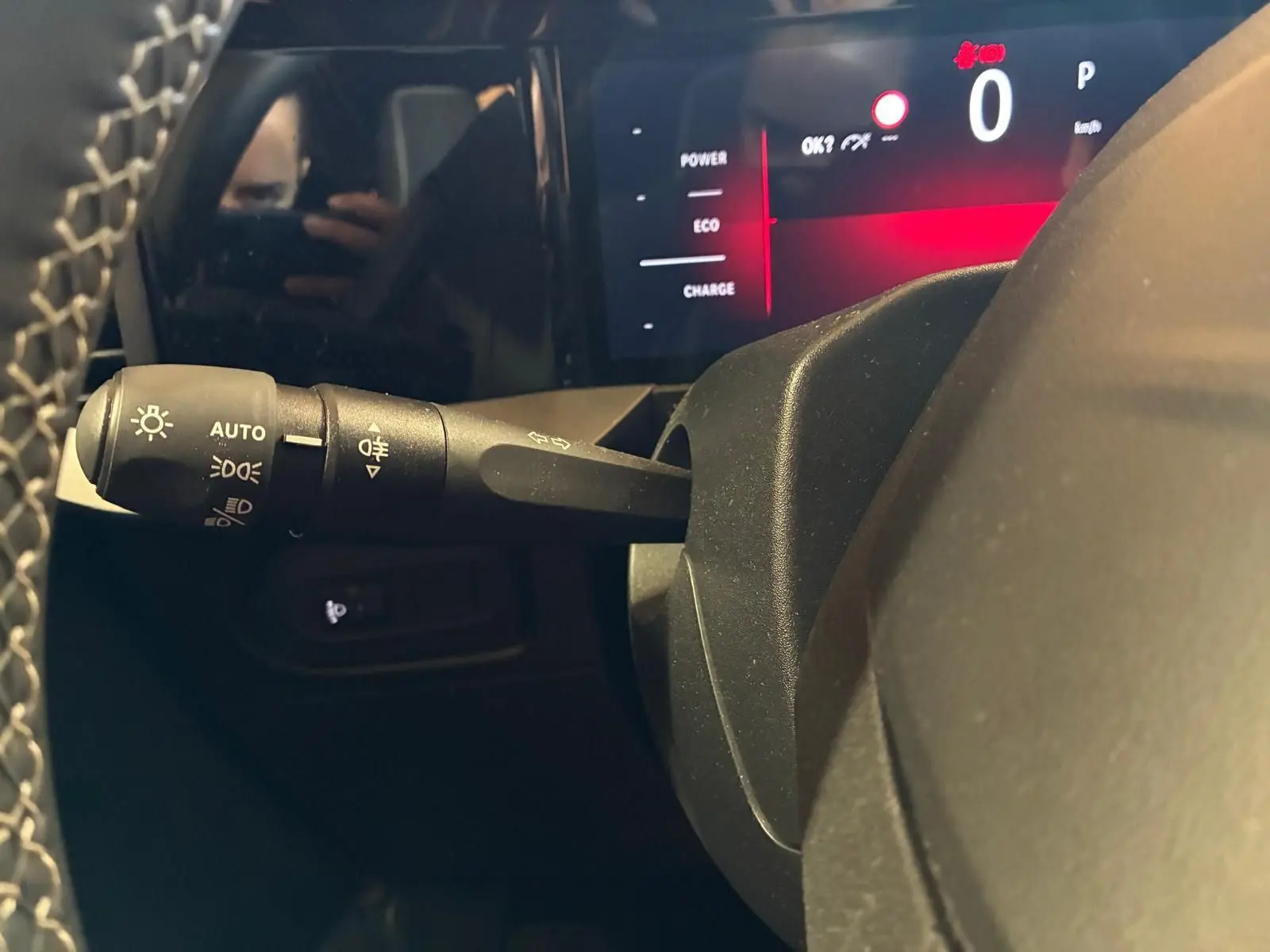 Détail intérieur du combiné d'instruments et du commodo d'éclairage à gauche du volant d'un Opel Mokka noir 2025.