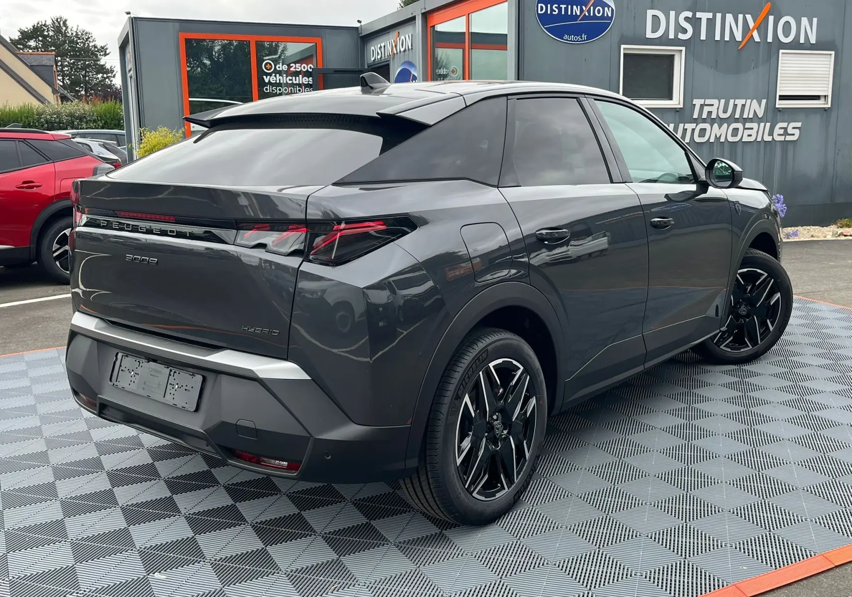 Peugeot 3008 hybride gris titane vu en 3/4 arrière droit avec jantes alliage noires et toit noir diamant.