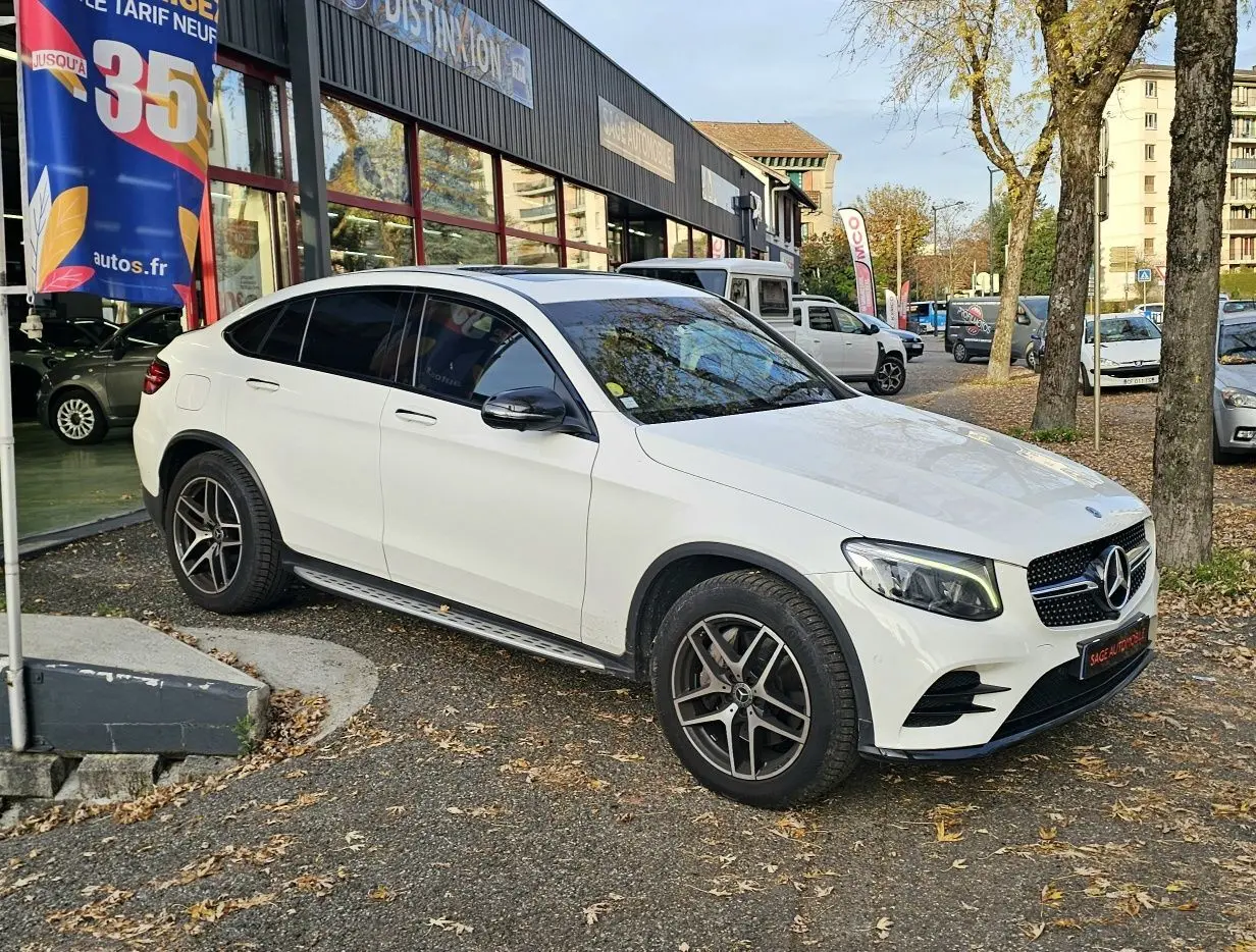 Vue 3/4 avant droite d'un Mercedes GLC 220 Coupé blanc 2018 avec jantes alliage et vitres teintées.
