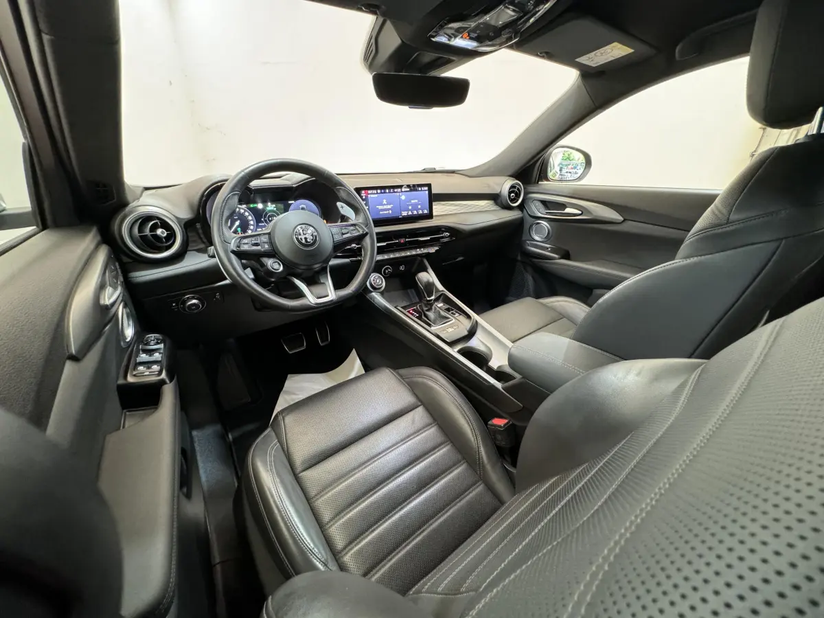 Intérieur noir de l'Alfa Romeo Tonale 2023 vu côté conducteur, avec tableau de bord digital et écran tactile central.