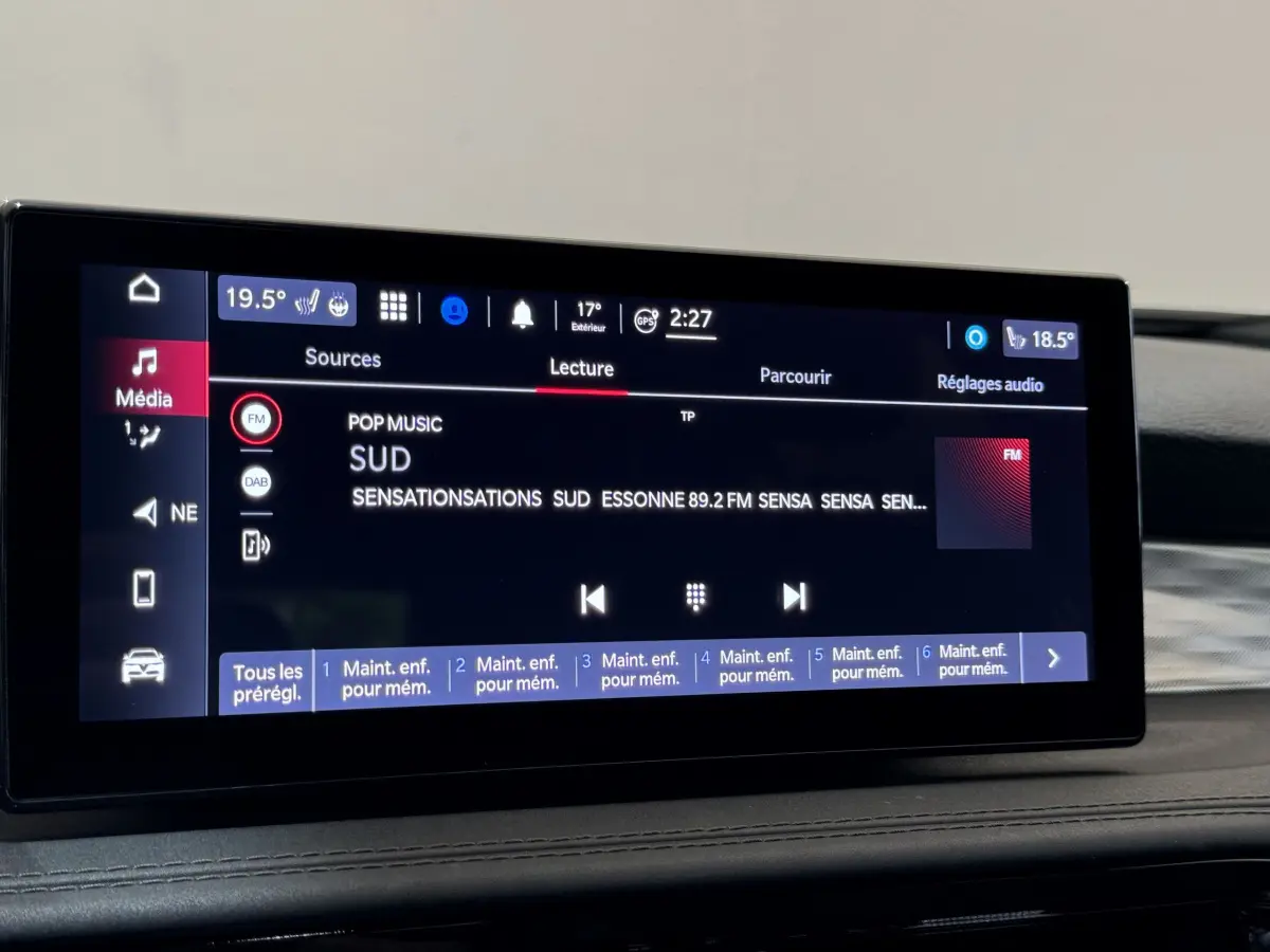 Écran tactile central affichant la radio FM dans l'habitacle de l'Alfa Romeo Tonale rouge, vue intérieure rapprochée.