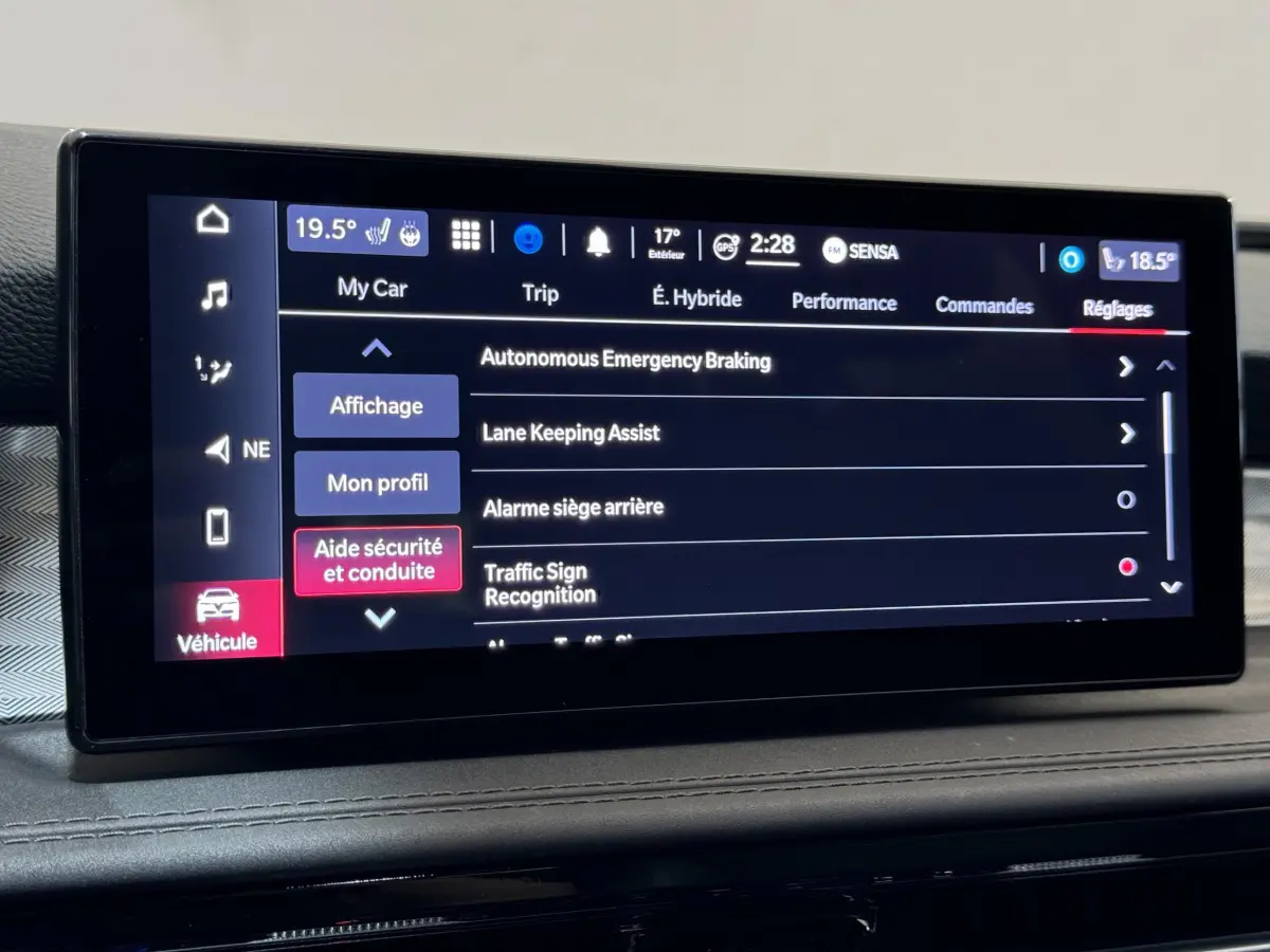 Écran tactile central affichant les réglages d'aide à la conduite de l'Alfa Romeo Tonale 1.3T PHEV rouge, vue intérieure.