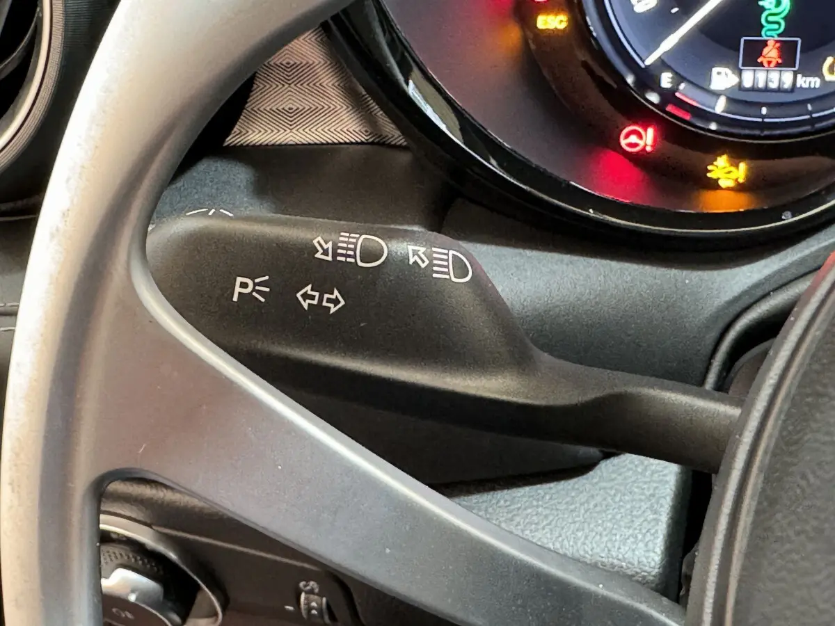 Gros plan sur la manette de clignotant noire dans l'habitacle de l'Alfa Romeo Tonale 2023 rouge hybride rechargeable.