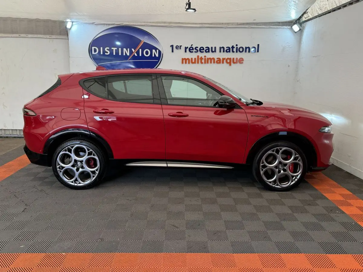 Profil droit de l'Alfa Romeo Tonale rouge 2023 avec jantes distinctives et détails noirs contrastants.