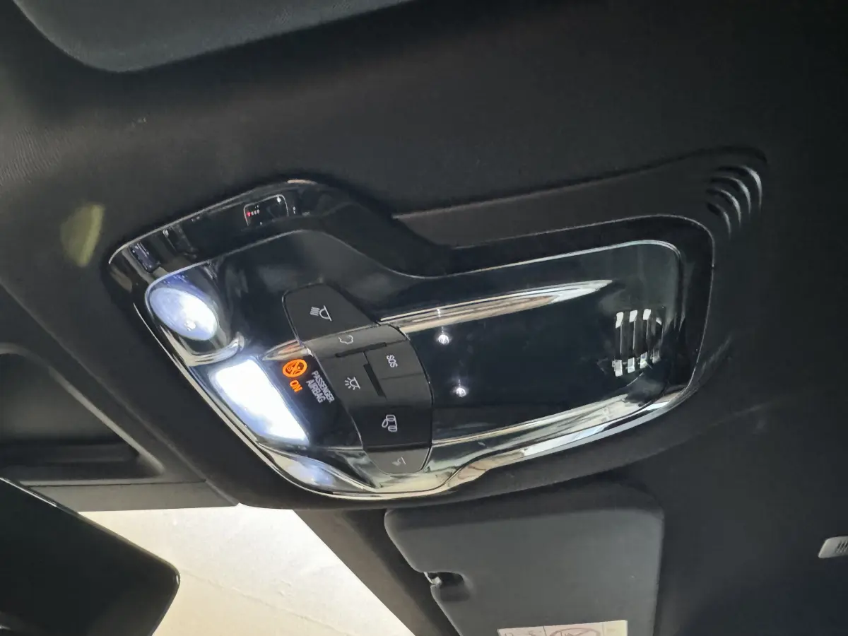 Plafonnier intérieur avec commandes d’éclairage et signalisation sur Alfa Romeo Tonale rouge, vue en contre-plongée.