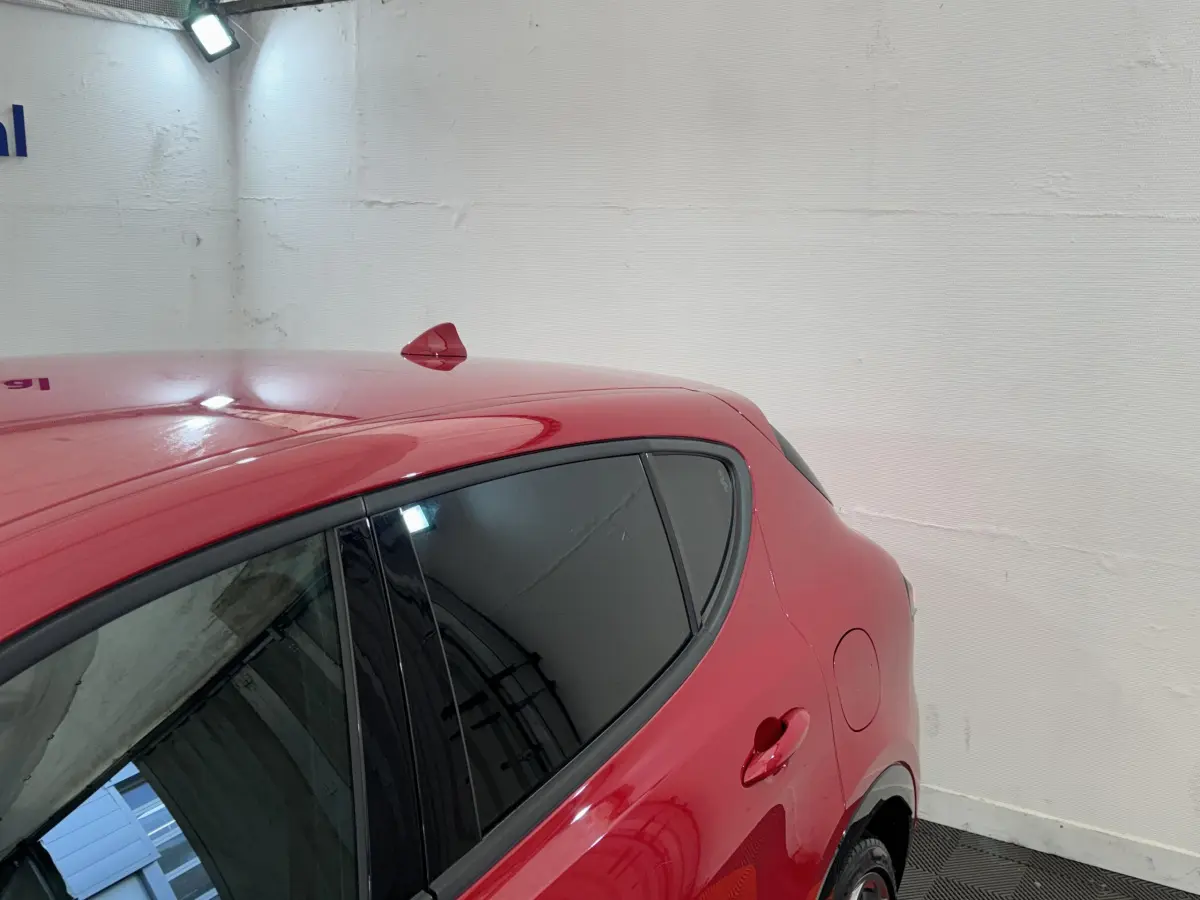 Vue côté droit arrière d'une Alfa Romeo Tonale rouge avec vitres teintées et antenne requin sur le toit