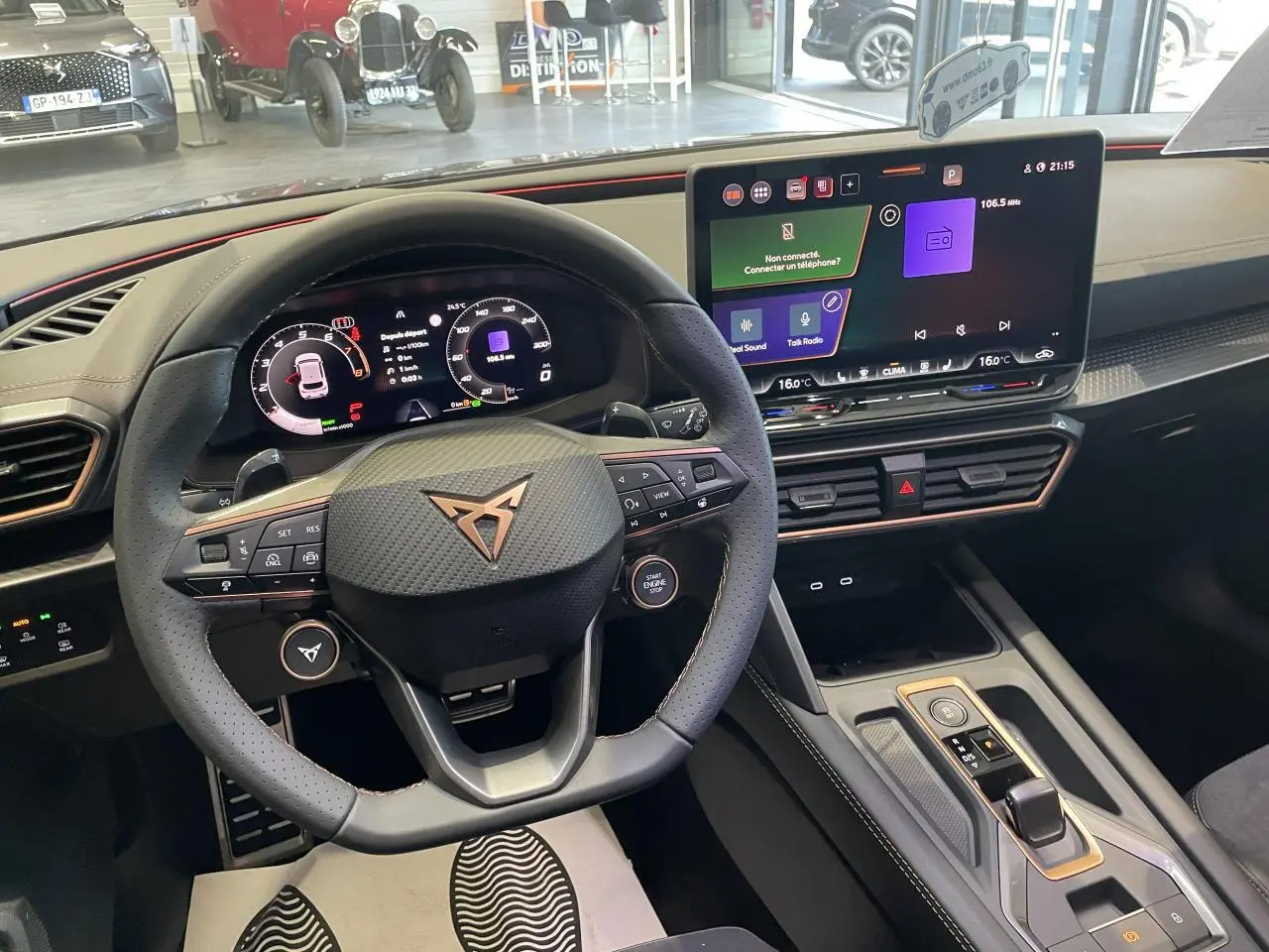 Vue intérieure centrée sur le volant CUPRA en cuir noir avec logo cuivré et écran tactile HD du tableau de bord.