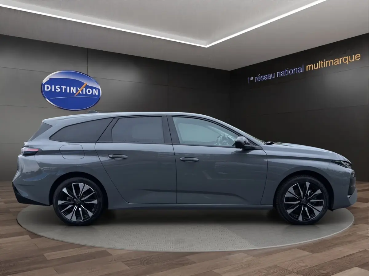Peugeot 308 Hybrid gris foncé vue de profil côté gauche, avec jantes alliage noires et toit légèrement incliné.