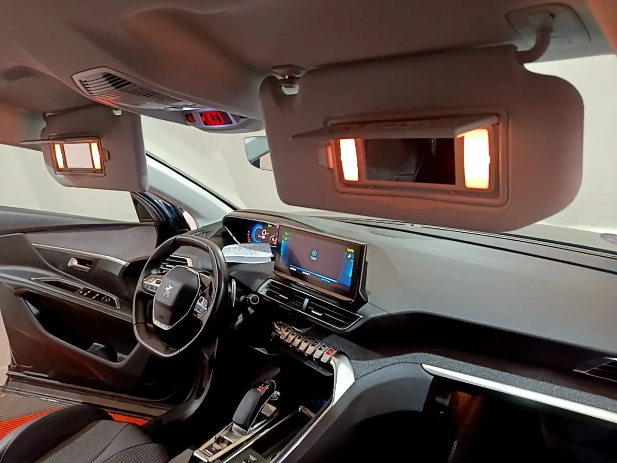 Intérieur du Peugeot 3008 hybride 2021 vu côté conducteur, tableau de bord moderne avec écran tactile allumé.