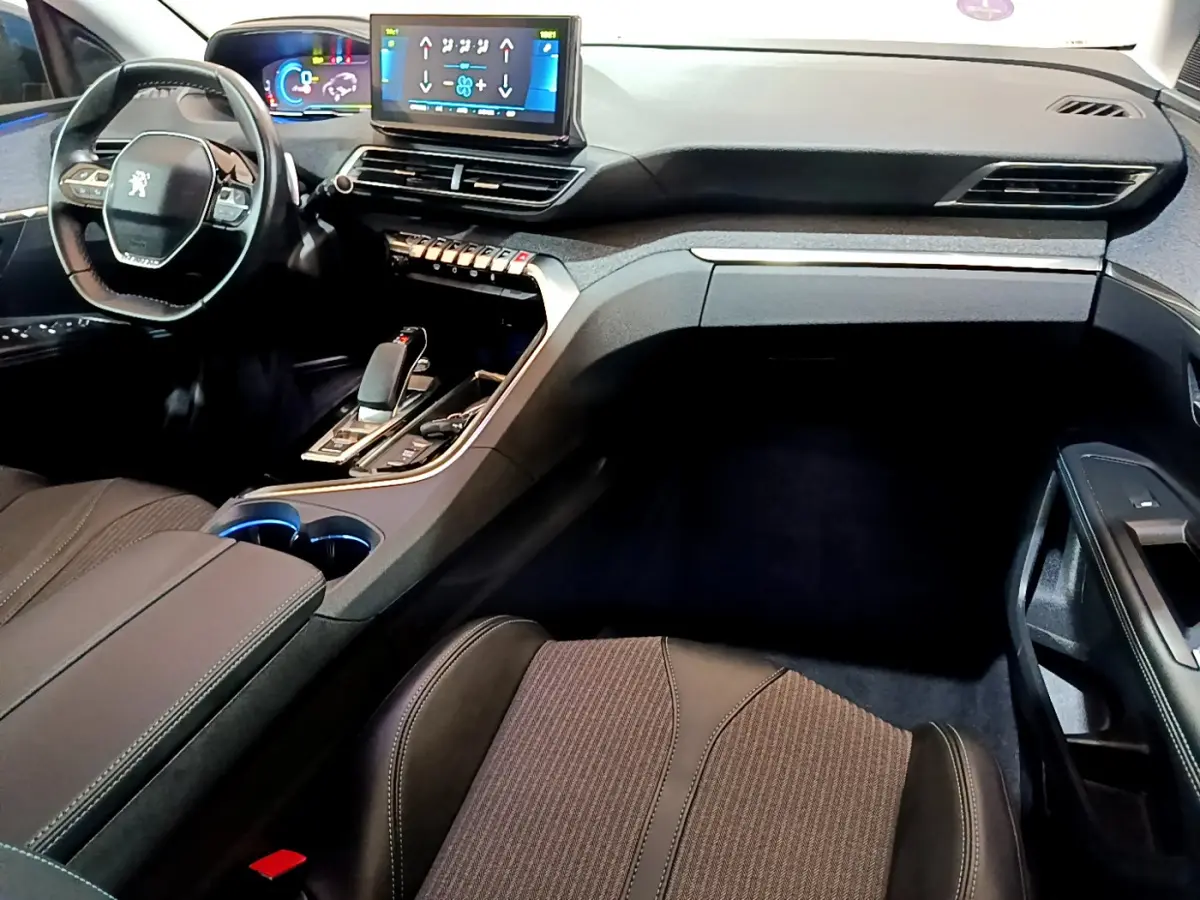 Intérieur noir du Peugeot 3008 hybride, vue côté passager avec tableau de bord et écran tactile central visible.