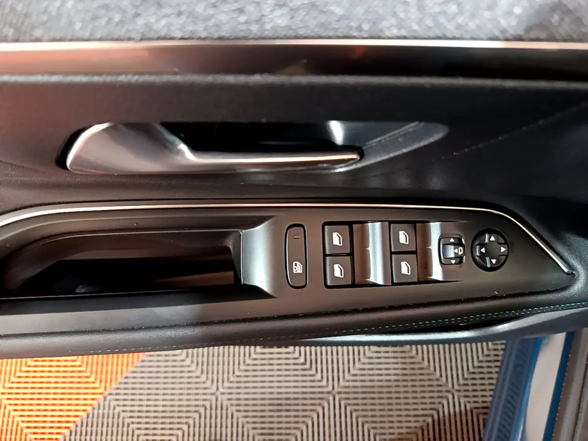 Vue rapprochée des commandes des vitres et rétroviseurs sur la porte côté conducteur du Peugeot 3008 bleu hybride rechargeable.