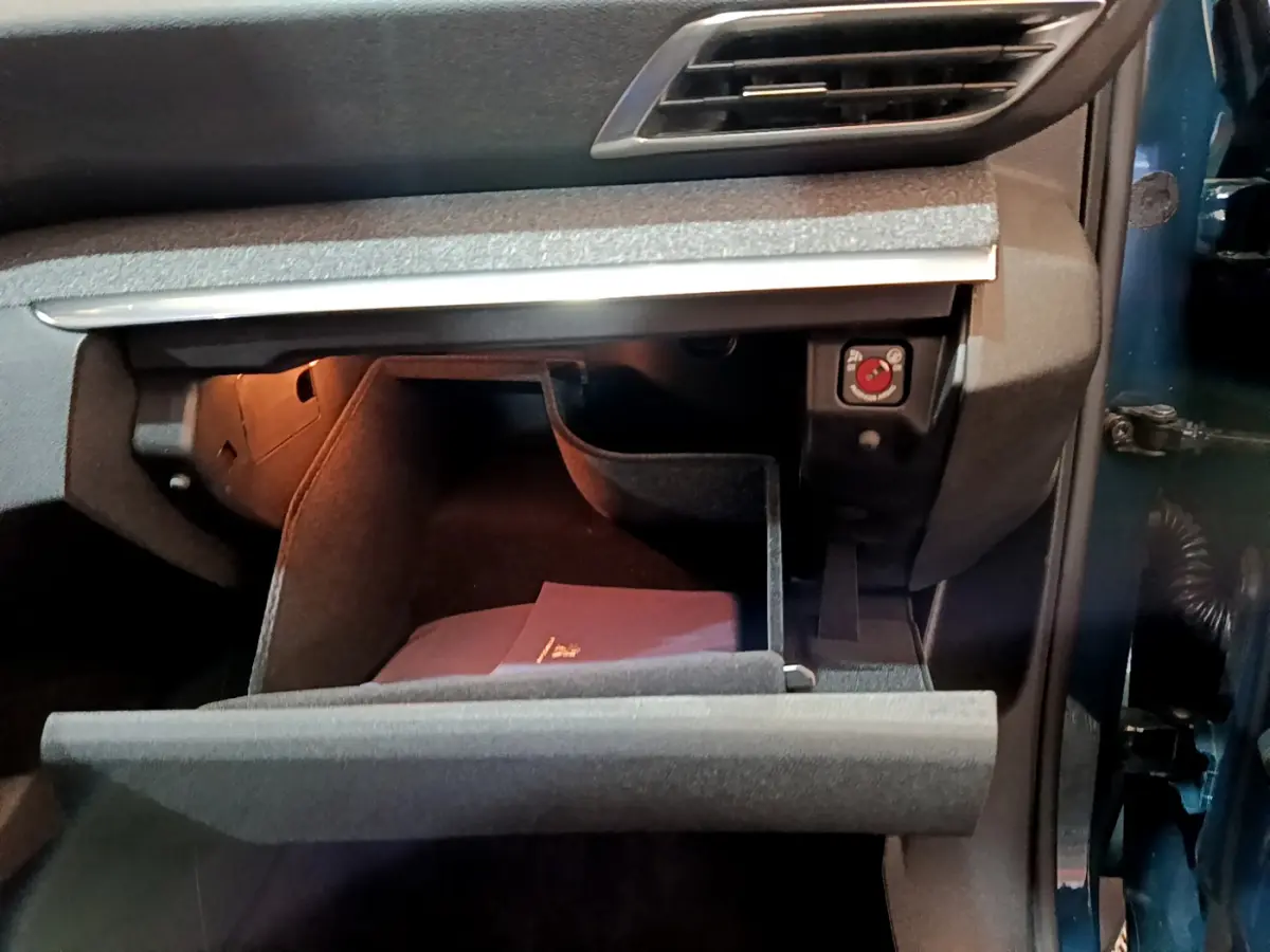 Vue rapprochée de la boîte à gants ouverte côté passager du Peugeot 3008 bleu hybride rechargeable 2021.