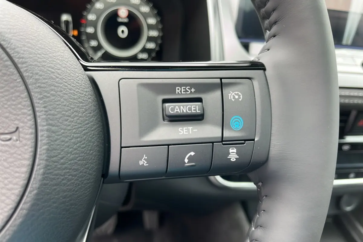 Gros plan sur les commandes multifonctions à droite du volant cuir du Nissan Qashqai E-POWER 205 Tekna Plus 2026.