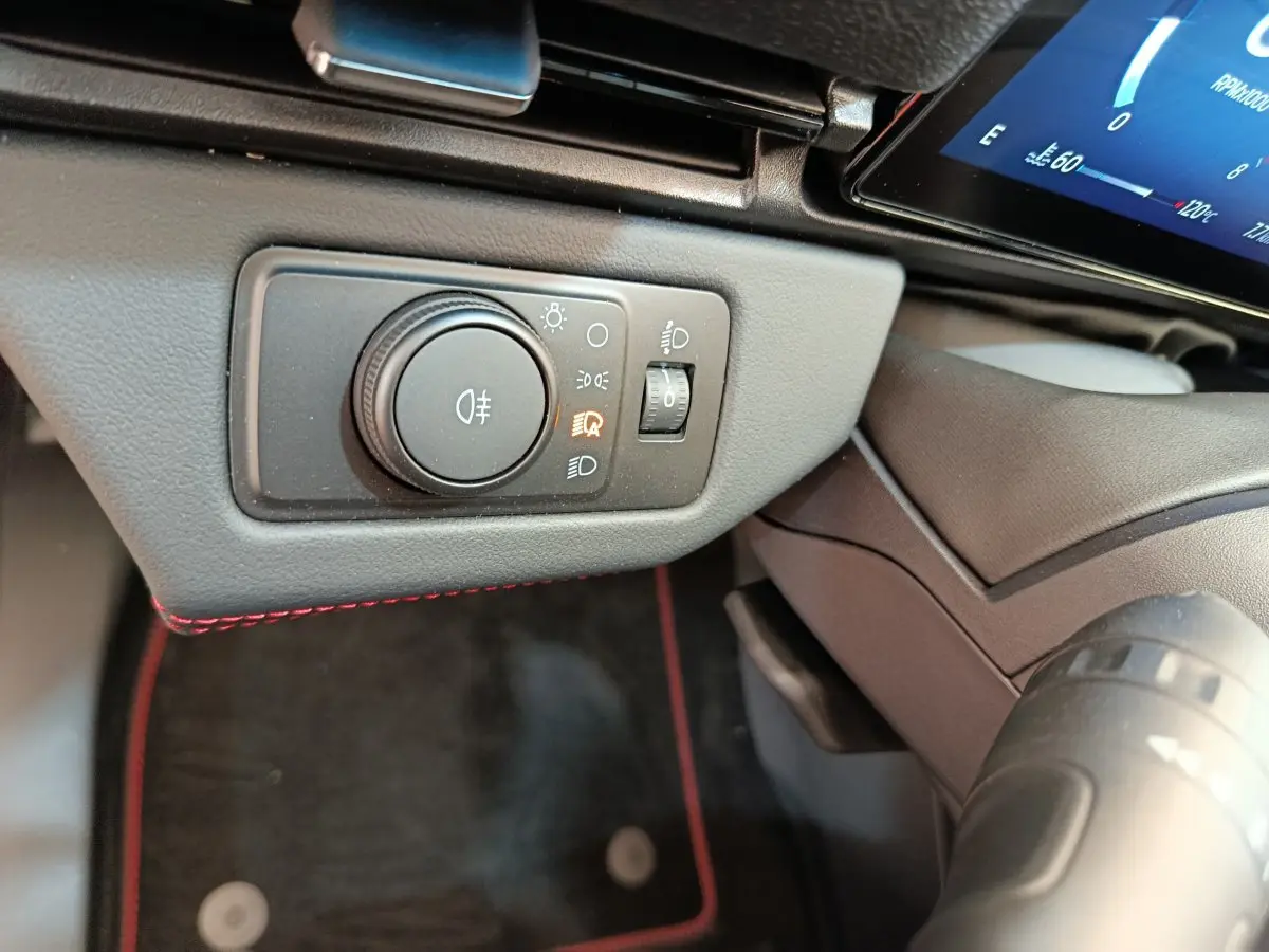 Gros plan sur le panneau de commande des phares à gauche du volant dans l’habitacle du Ford Puma bleu 2025.