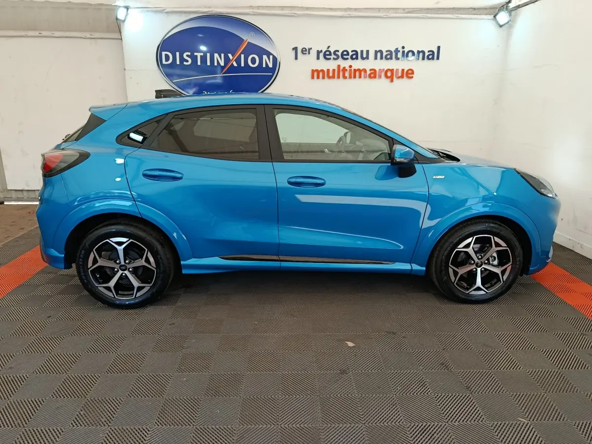 Ford Puma 2025 bleu en profil côté gauche, avec jantes alliage noires et logo ST-LINE visible sur l'aile avant.