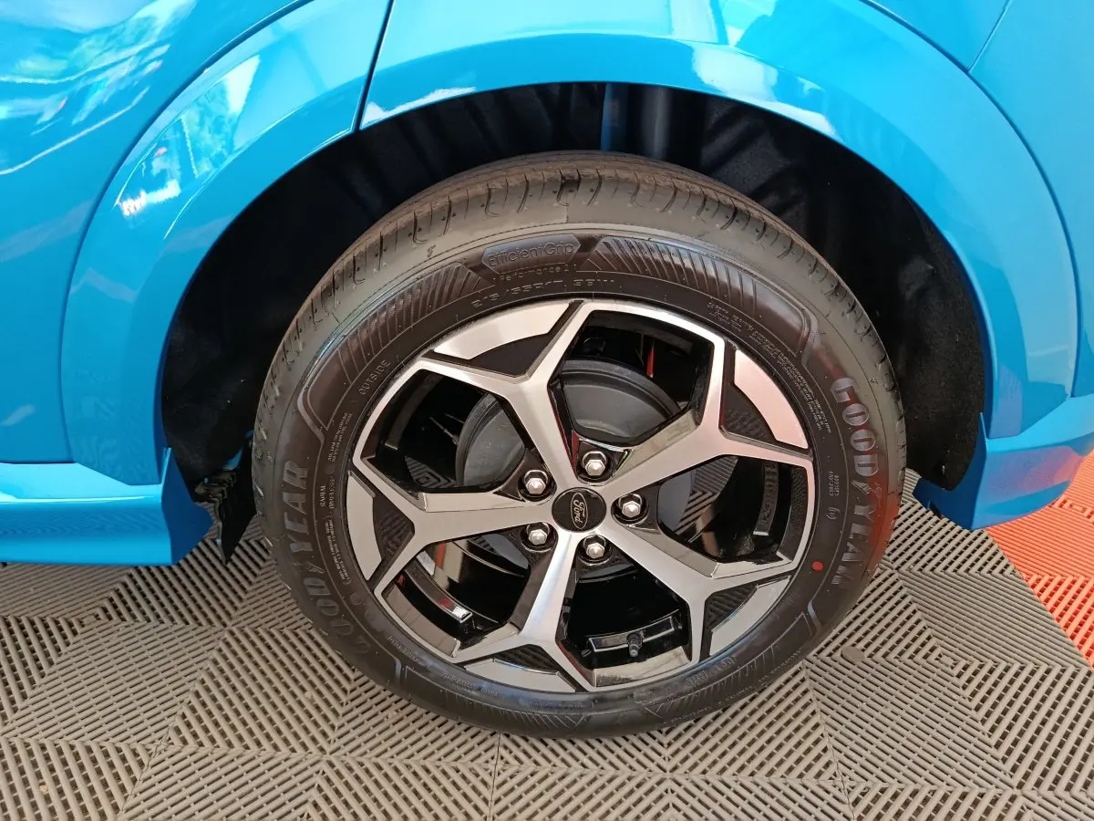 Gros plan sur la roue avant droite du Ford Puma bleu 2025, avec jante alliage noire et argentée design moderne.