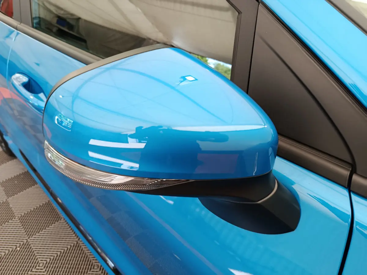 Rétroviseur côté gauche bleu vif du Ford Puma 2025 avec clignotant intégré, vue rapprochée sur la portière.