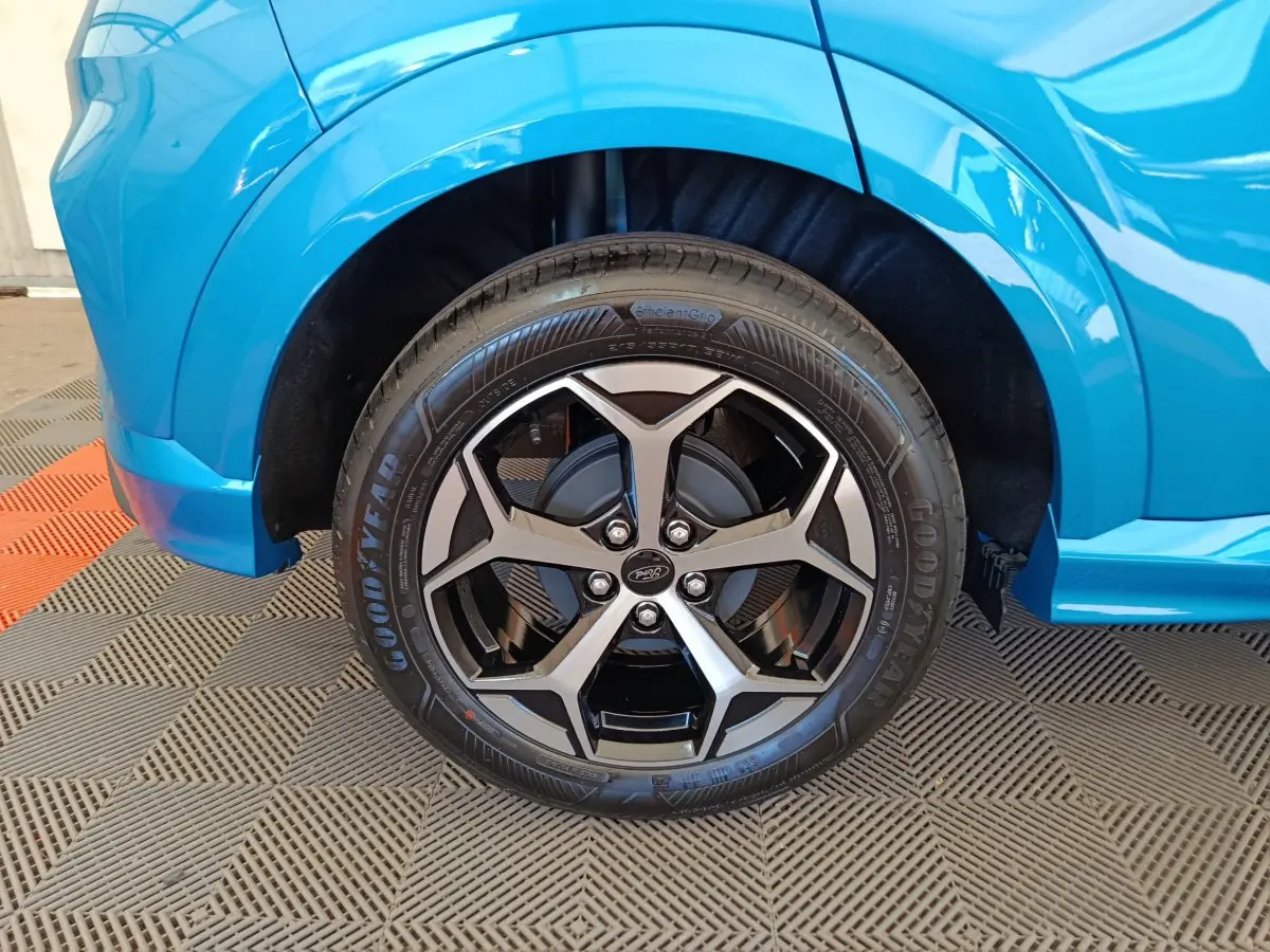 Gros plan sur la roue avant gauche du Ford Puma bleu 2025 avec jante alliage noire et argentée design moderne.