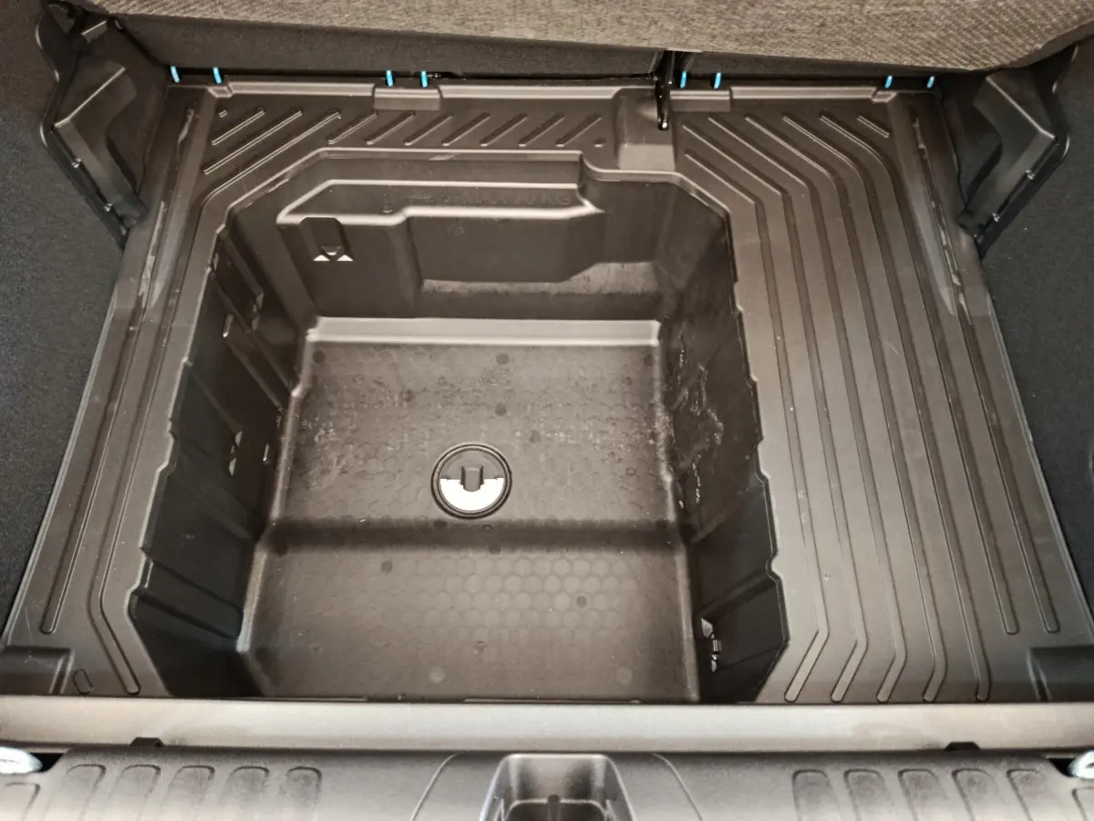 Coffre ouvert vu de dessus du Ford Puma bleu, montrant le compartiment de rangement sous la tablette arrière.