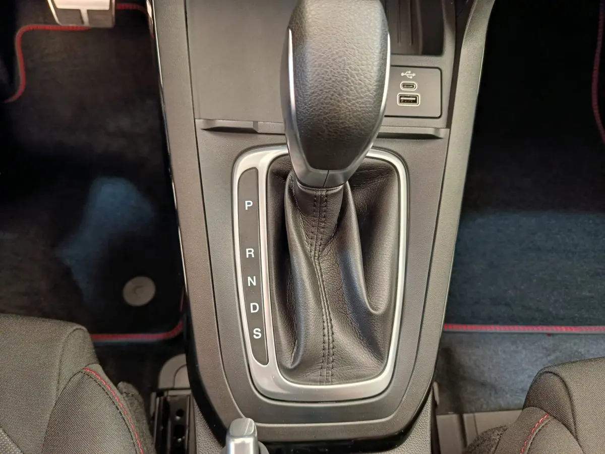 Le levier de boîte automatique noir du Ford Puma 2025 vu de dessus avec coutures rouges sur les sièges adjacents.