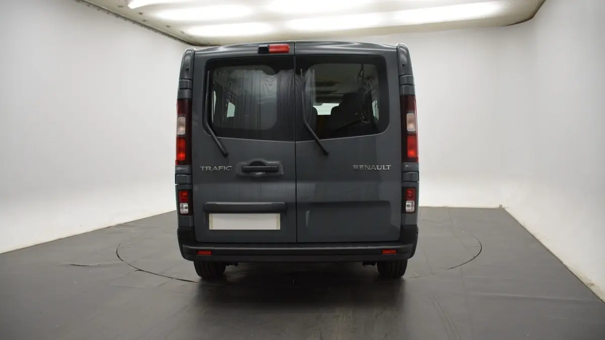 Vue arrière du Renault Trafic Fourgon gris clair avec portes battantes et essuie-glaces arrière visibles.