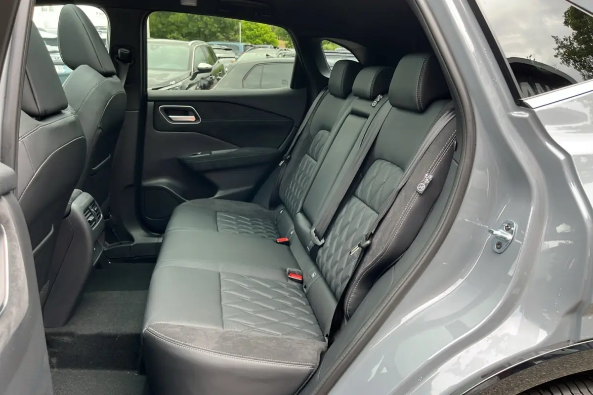 Vue intérieure côté droit sur la banquette arrière cuir noire avec surpiqûres du Nissan Qashqai gris argile 2026.