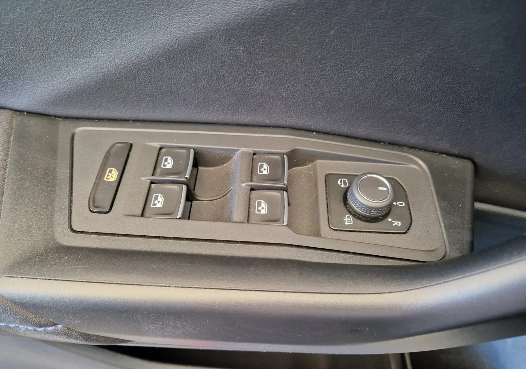 Panneau de commandes des vitres et rétroviseurs côté conducteur du Volkswagen T-Roc bleu Lapiz 2022, intérieur noir.