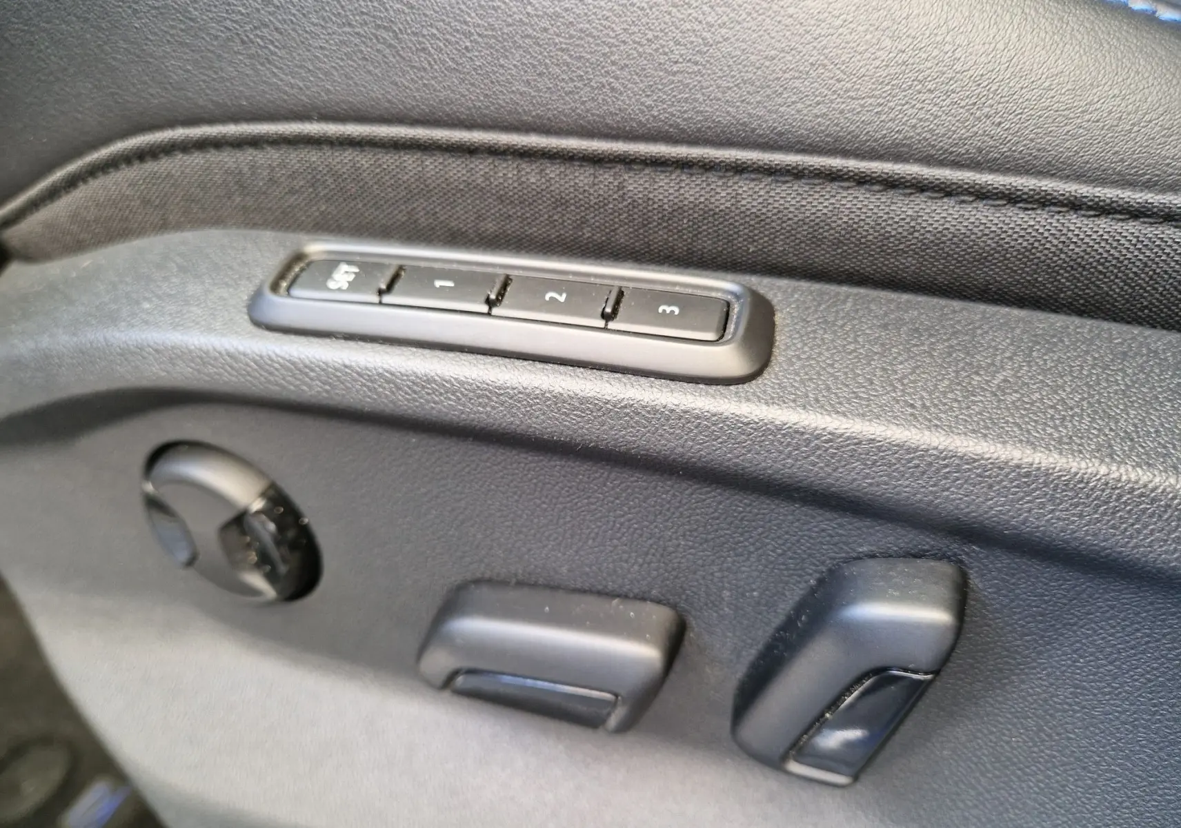 Commandes de réglage électrique des sièges en cuir noir dans un Volkswagen T-Roc 2022, version R bleu Lapiz.