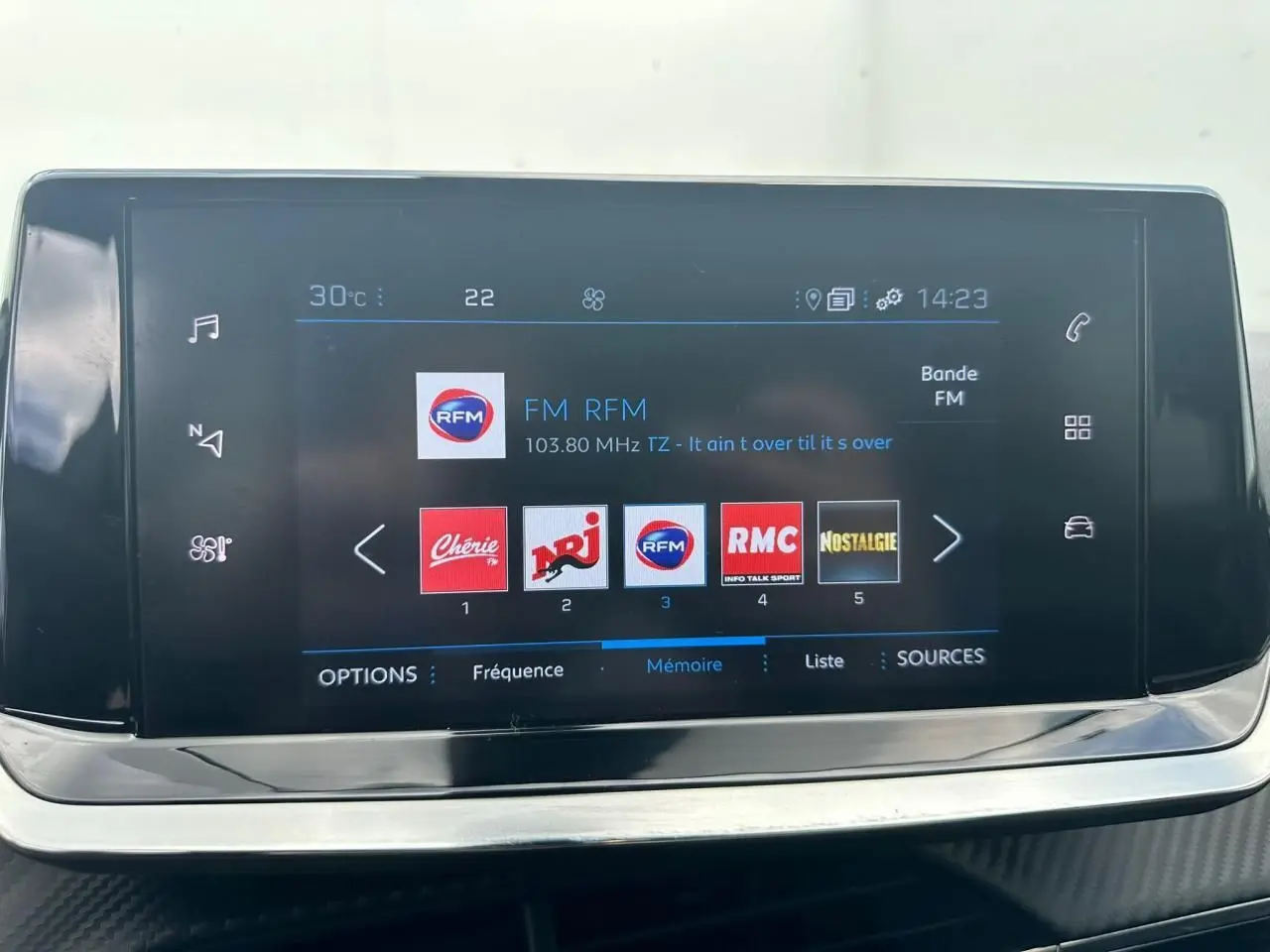 Écran tactile 7 pouces du système multimédia de la Peugeot 2008 gris clair affichant les stations radio FM.