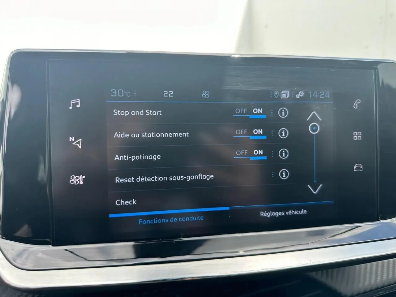 Écran tactile central du Peugeot 2008 gris clair affichant les réglages d'aides à la conduite et température intérieure