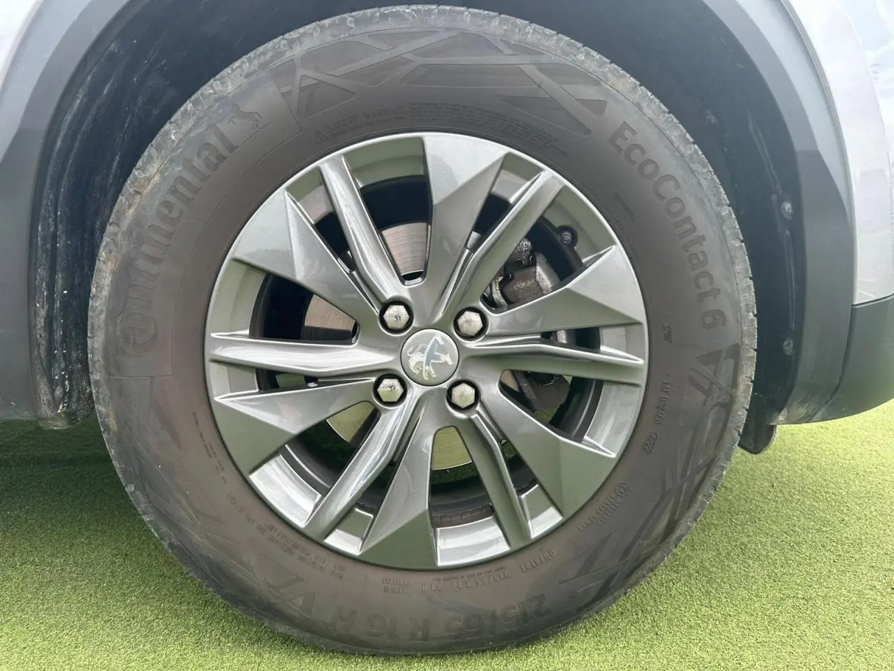 Gros plan sur la roue avant gauche du Peugeot 2008 gris clair avec jante alliage 16'' Elborn.