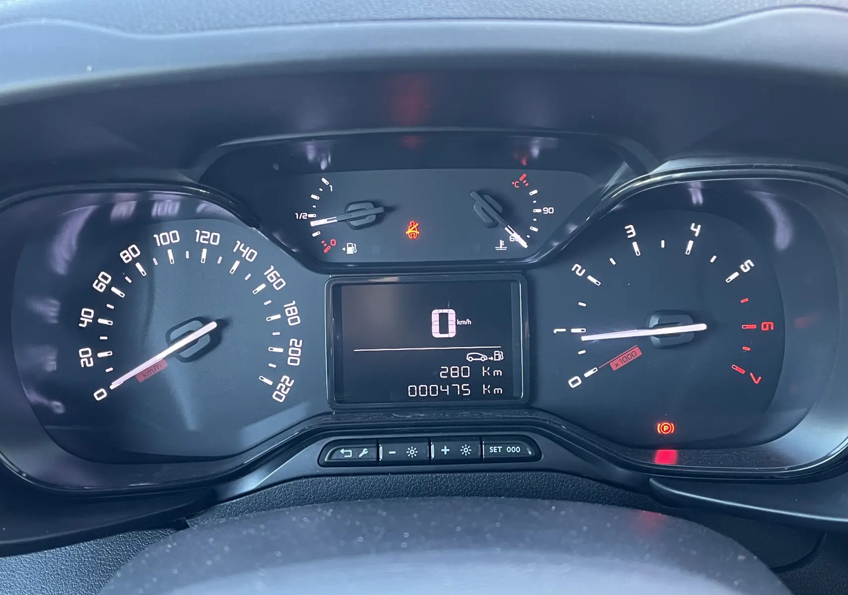 Vue rapprochée du tableau de bord numérique du Toyota Proace City 2023, affichant 475 km au compteur.