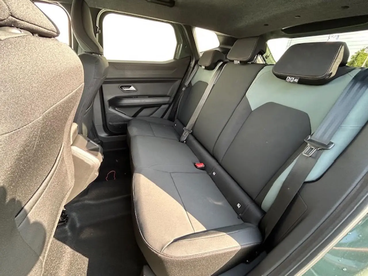 Vue intérieure côté droit sur la banquette arrière noire et kaki du Dacia Duster III 2025 avec ceinture de sécurité visible.