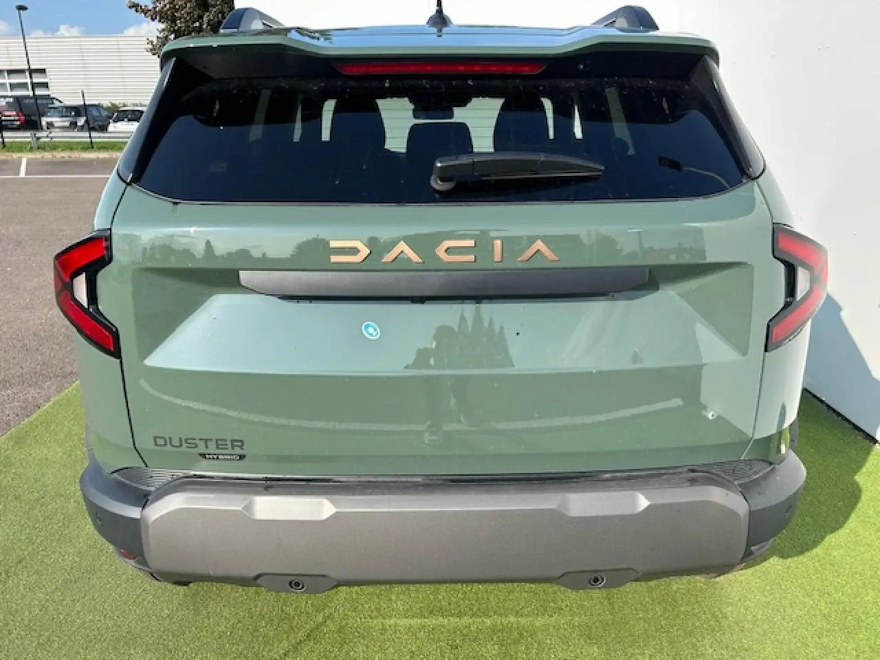 Vue arrière du Dacia Duster III 1.6 Hybrid 140 4x2 en kaki dusty avec logo doré et feux arrière en forme de C.