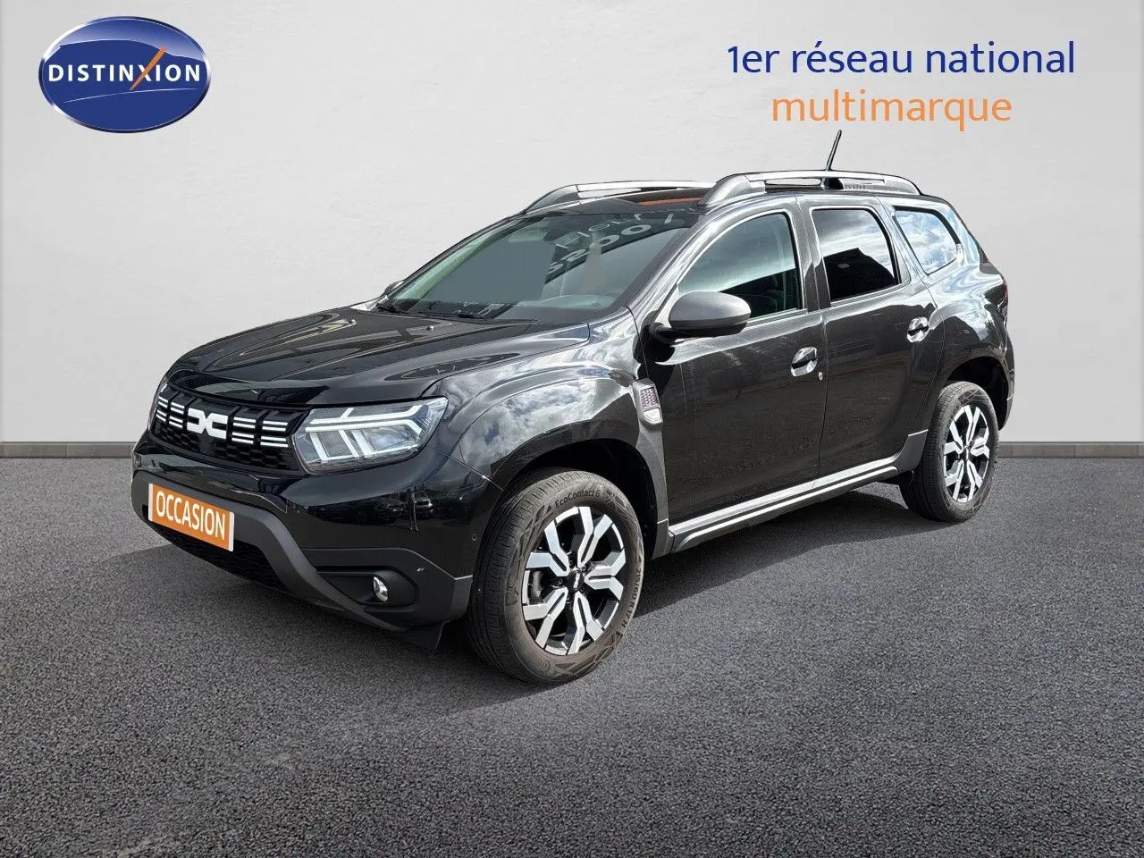 Dacia Duster noir en 3/4 avant droit, mettant en valeur ses jantes bicolores et sa calandre distinctive.