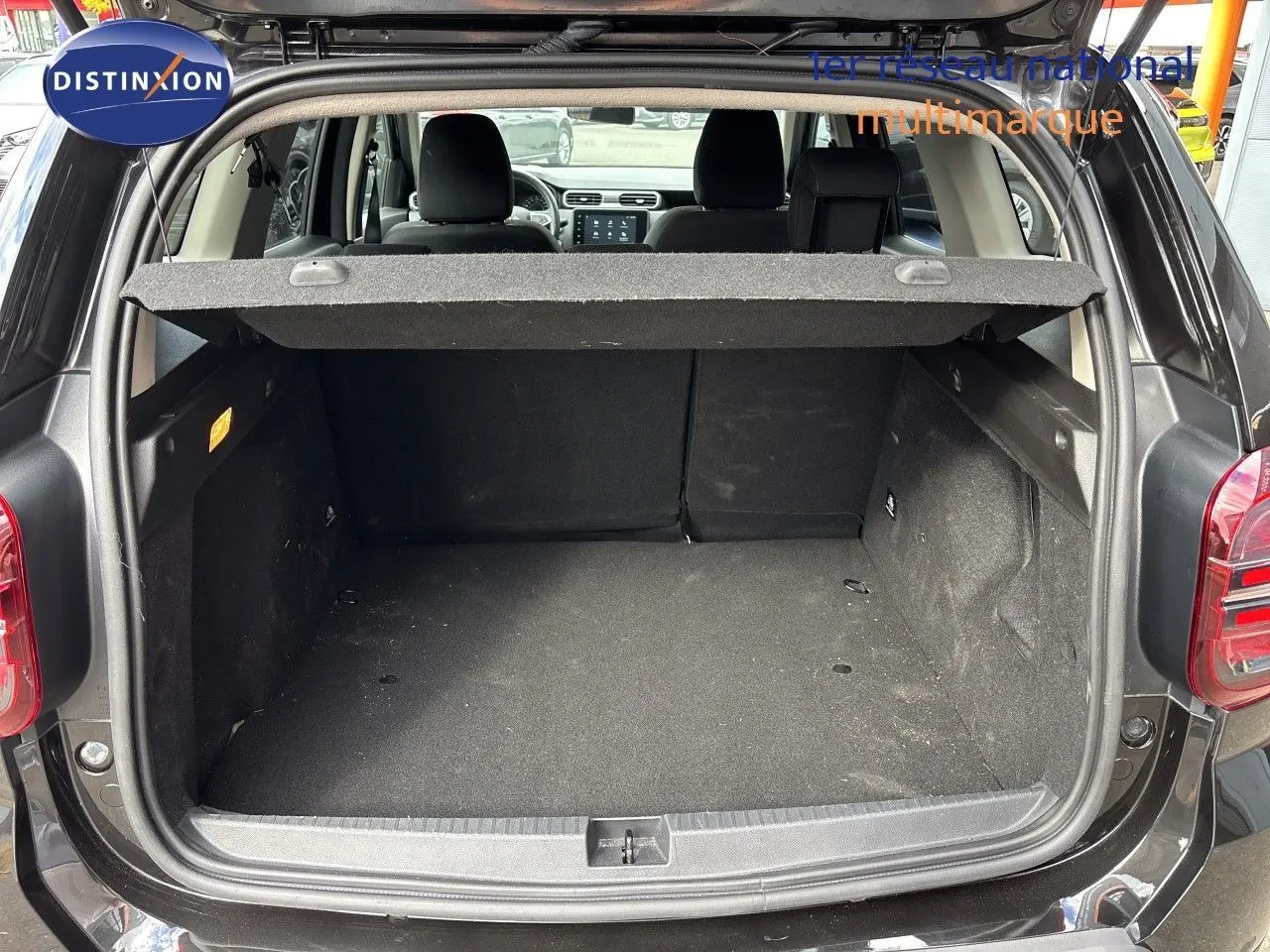 Coffre ouvert du Dacia Duster noir 2024, vue arrière montrant l'espace de chargement et l'intérieur des sièges arrière.