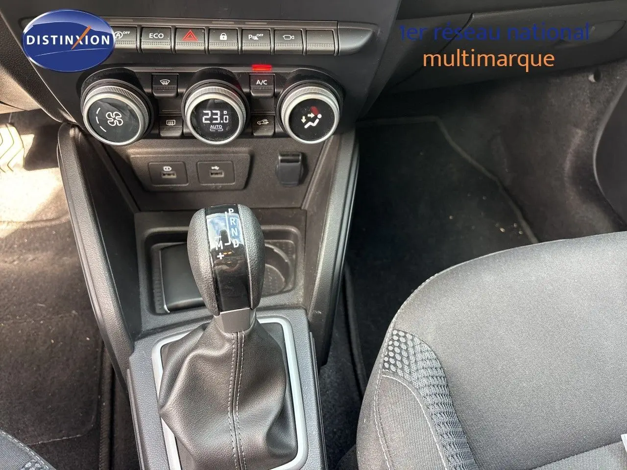 Gros plan sur la console centrale du Dacia Duster noir 2024, mettant en valeur le levier de vitesse automatique et les commandes de climatisation.