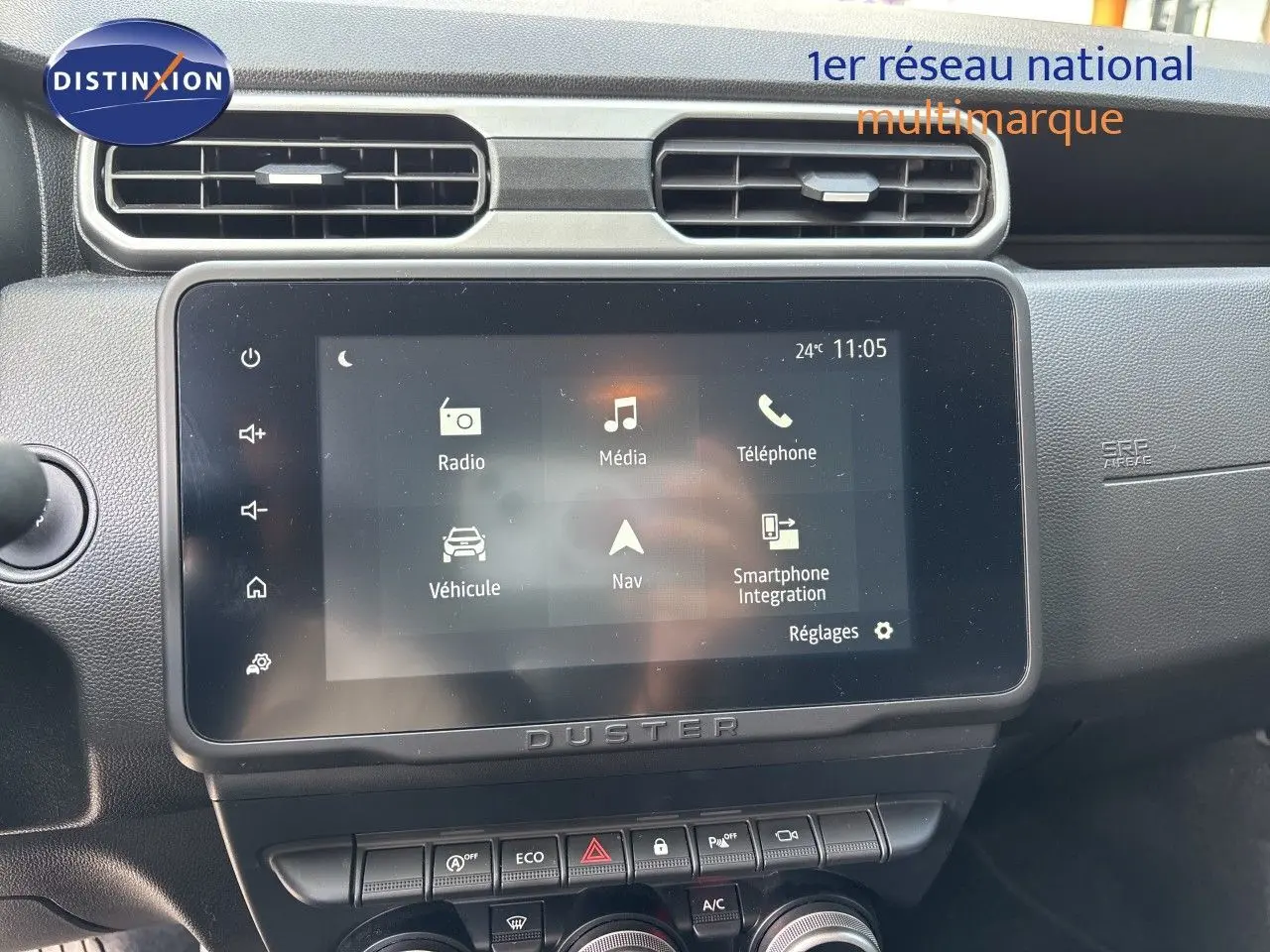 Intérieur du Dacia Duster noir 2024, vue sur la console centrale avec écran tactile et commande de climatisation digitale.